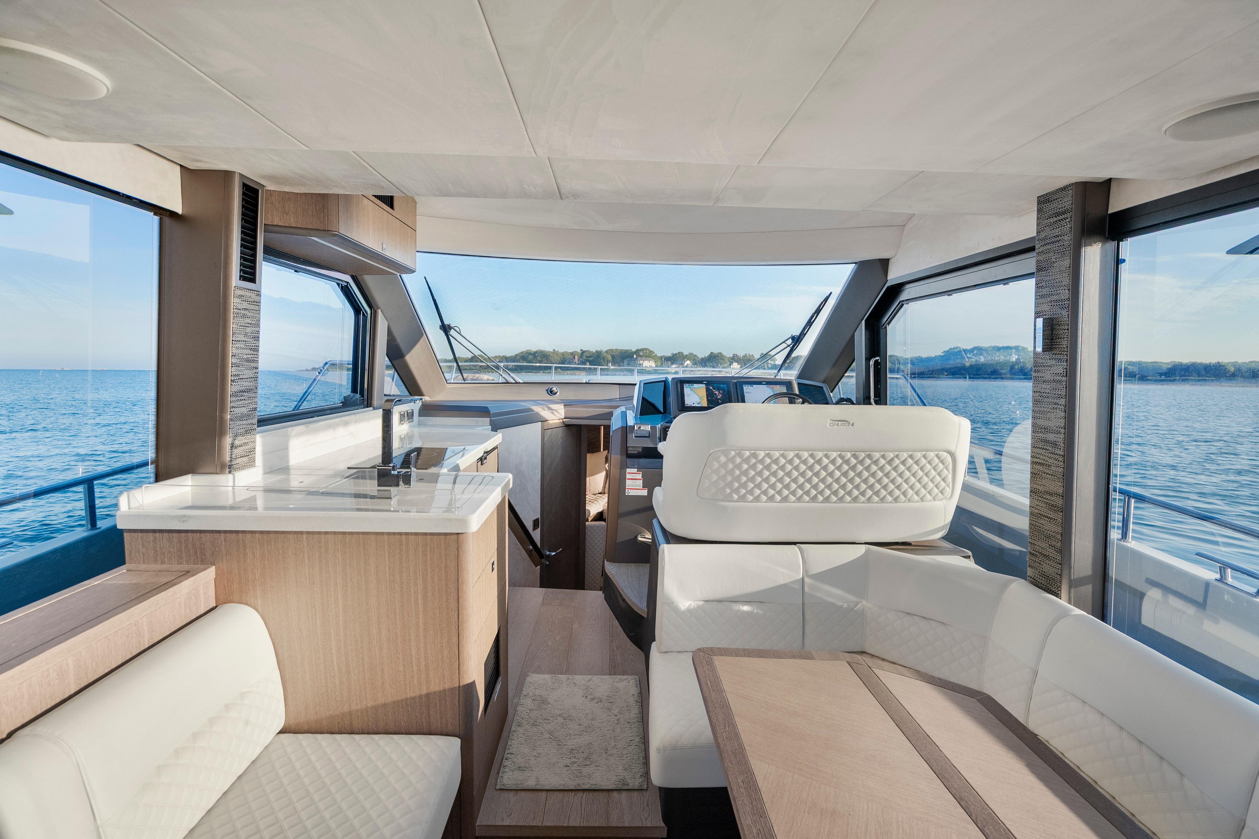 Luxurious interior of 2023 Galeon 400 Fly yacht with panoramic windows and elegant seating.