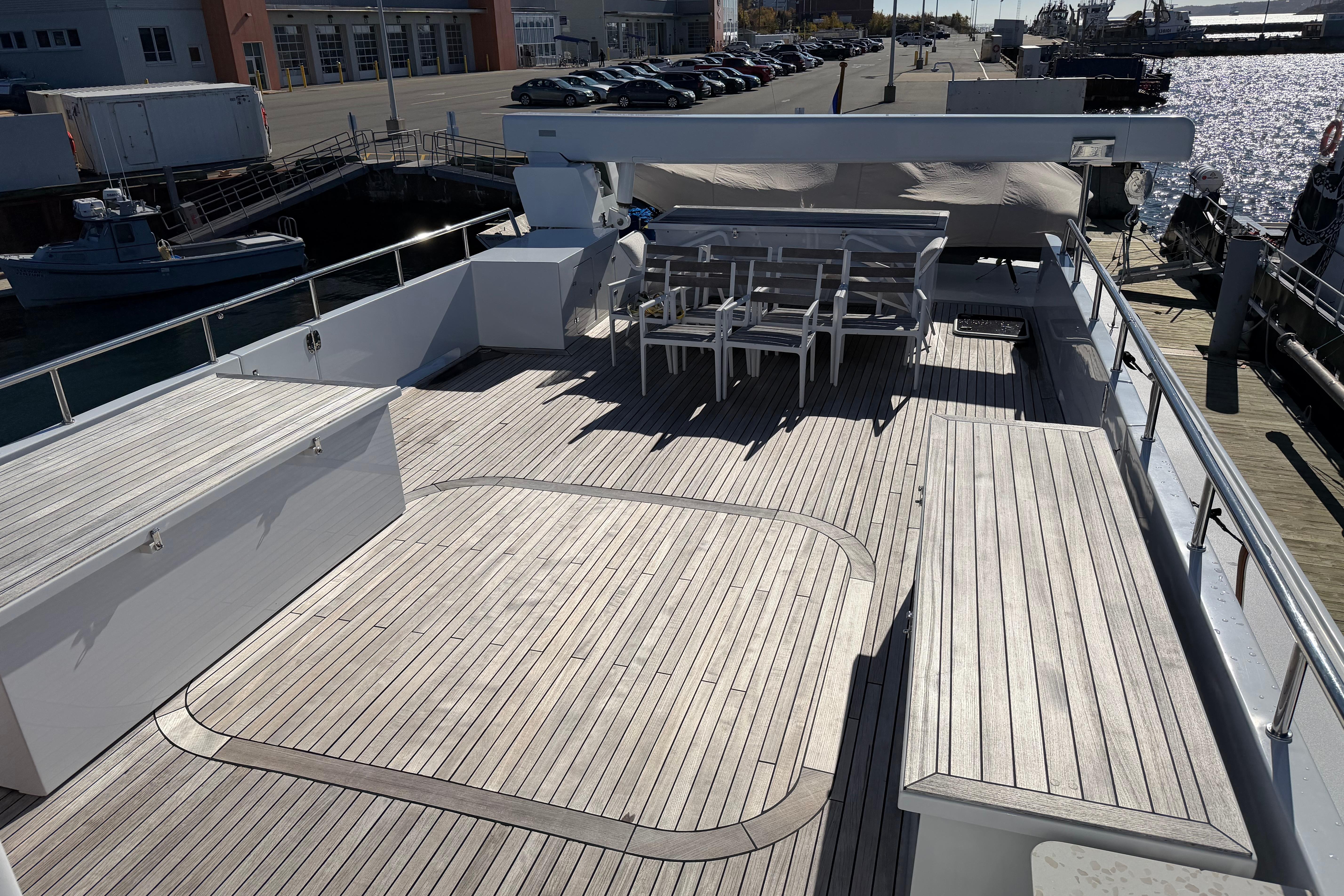 Spacious deck of 2001 Doogersbank Vipack yacht with wooden flooring and seating area.