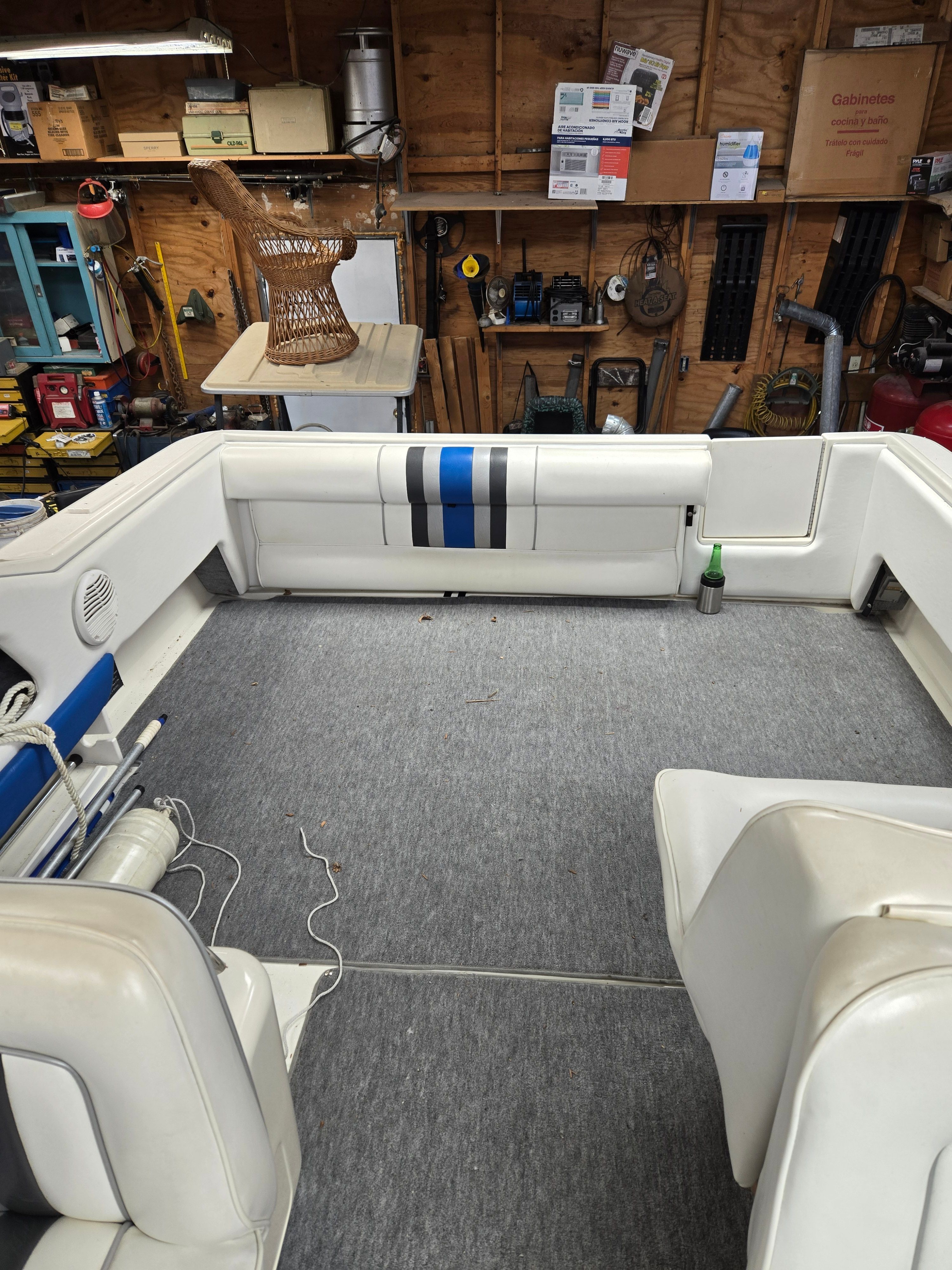Interior of a 1991 Sea Ray 250 Weekender with gray carpet and white seating.