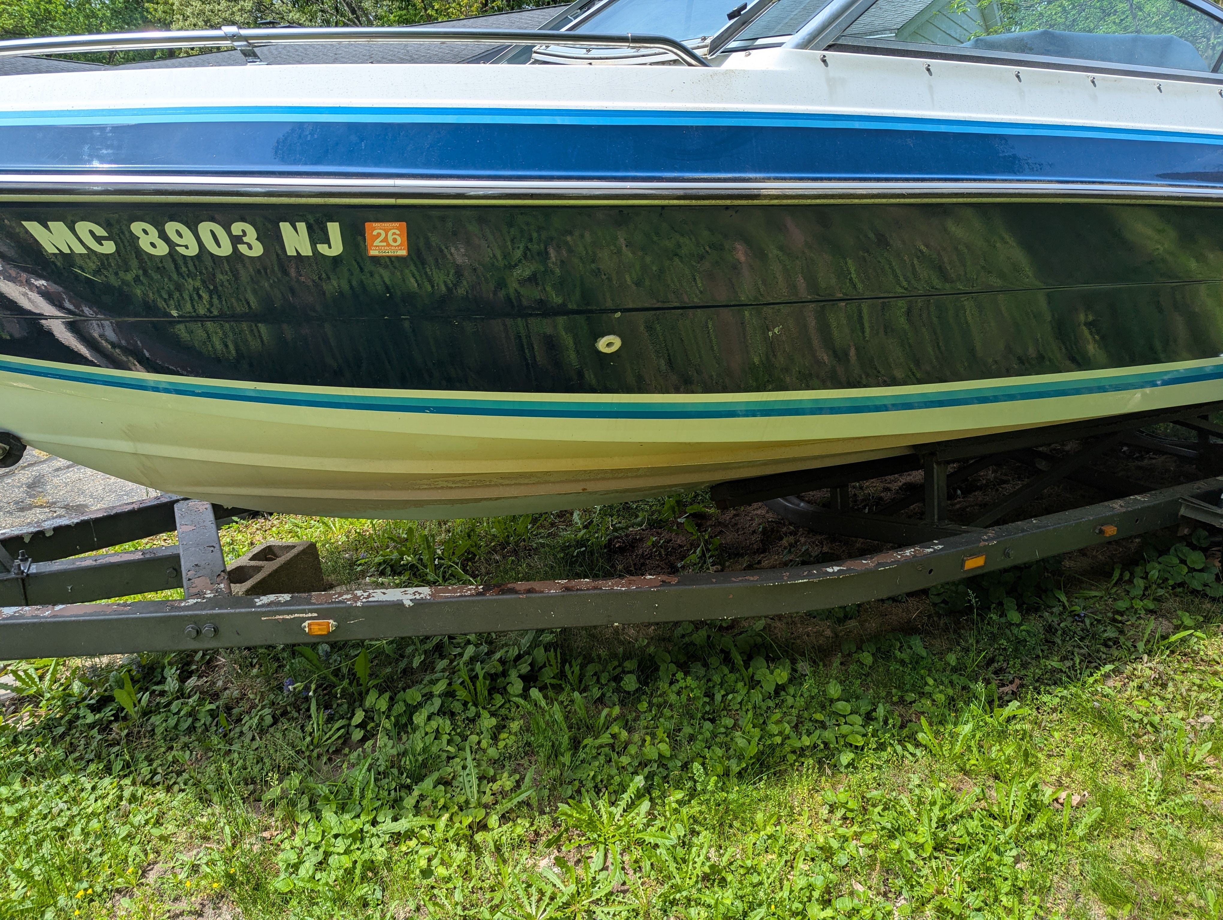1988 Four Winns 200 Horizon boat on trailer in greenery.
