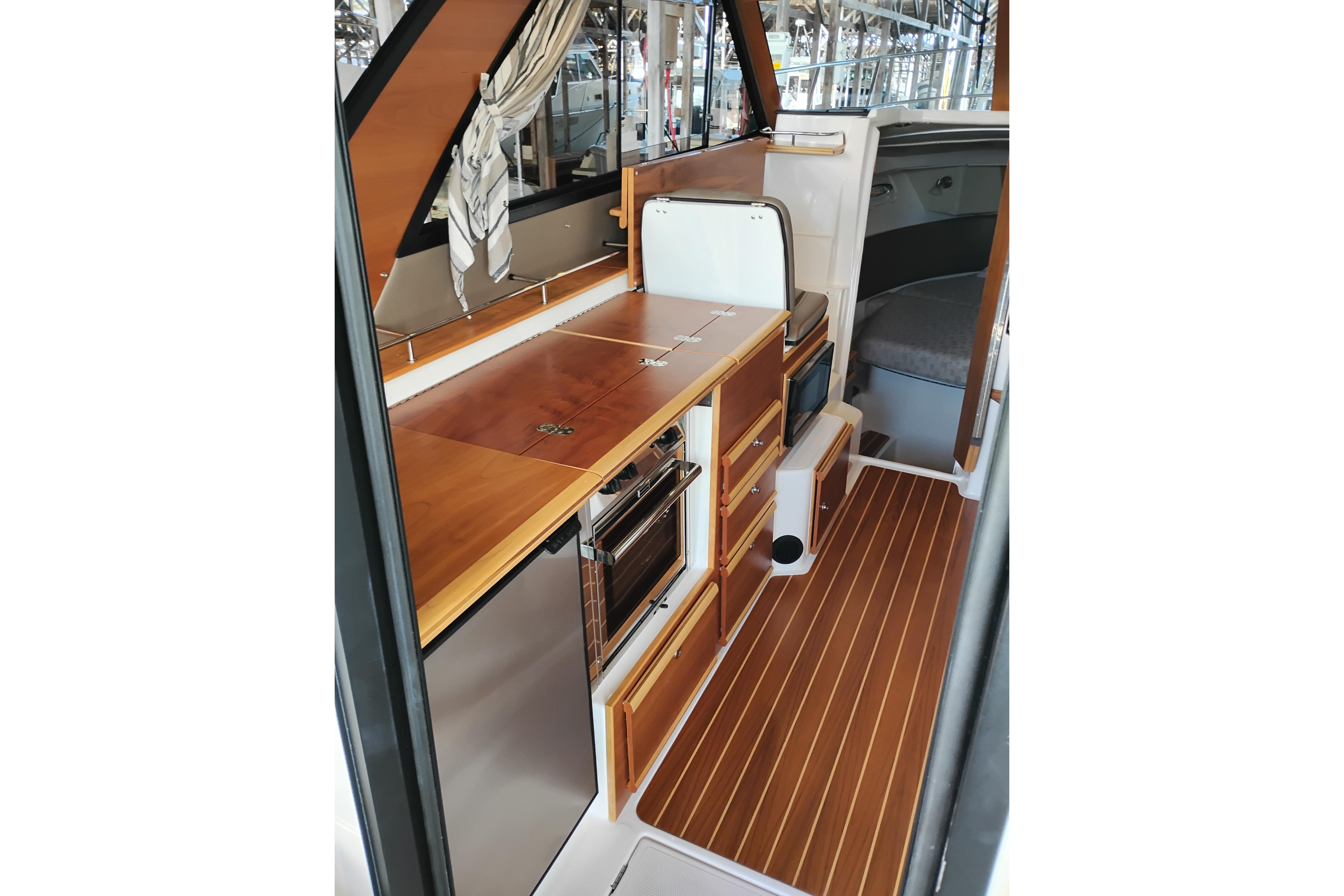 2022 Cutwater C-32 Coupe interior with wood cabinetry and modern appliances.
