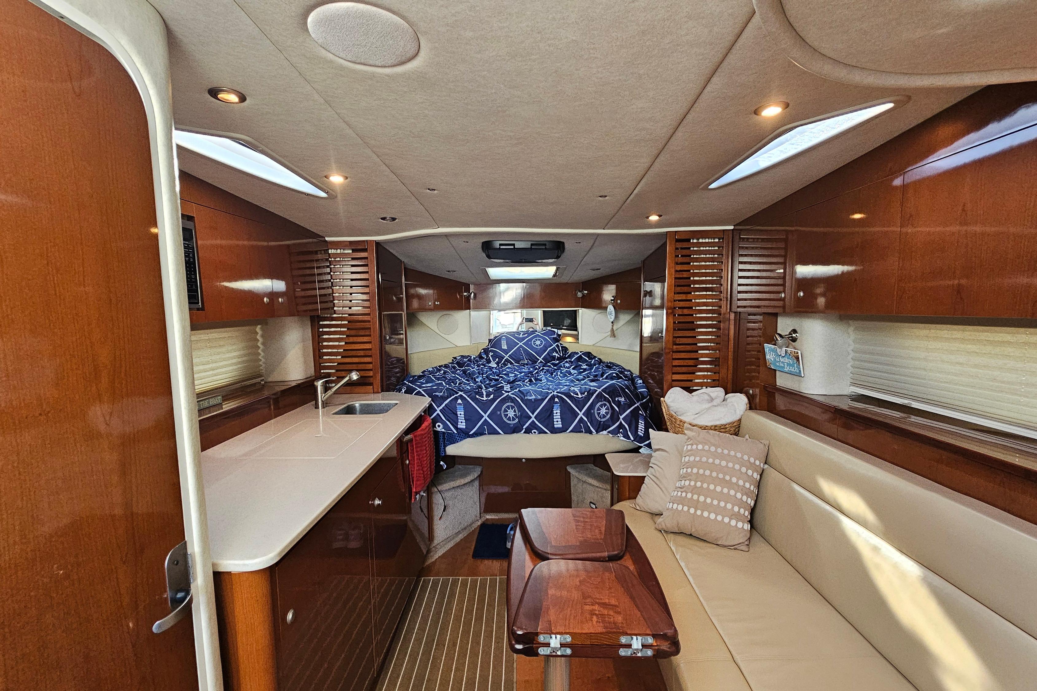 Luxurious interior of a 2008 Sea Ray Sundancer 350 yacht with cozy seating and elegant wood finishes.