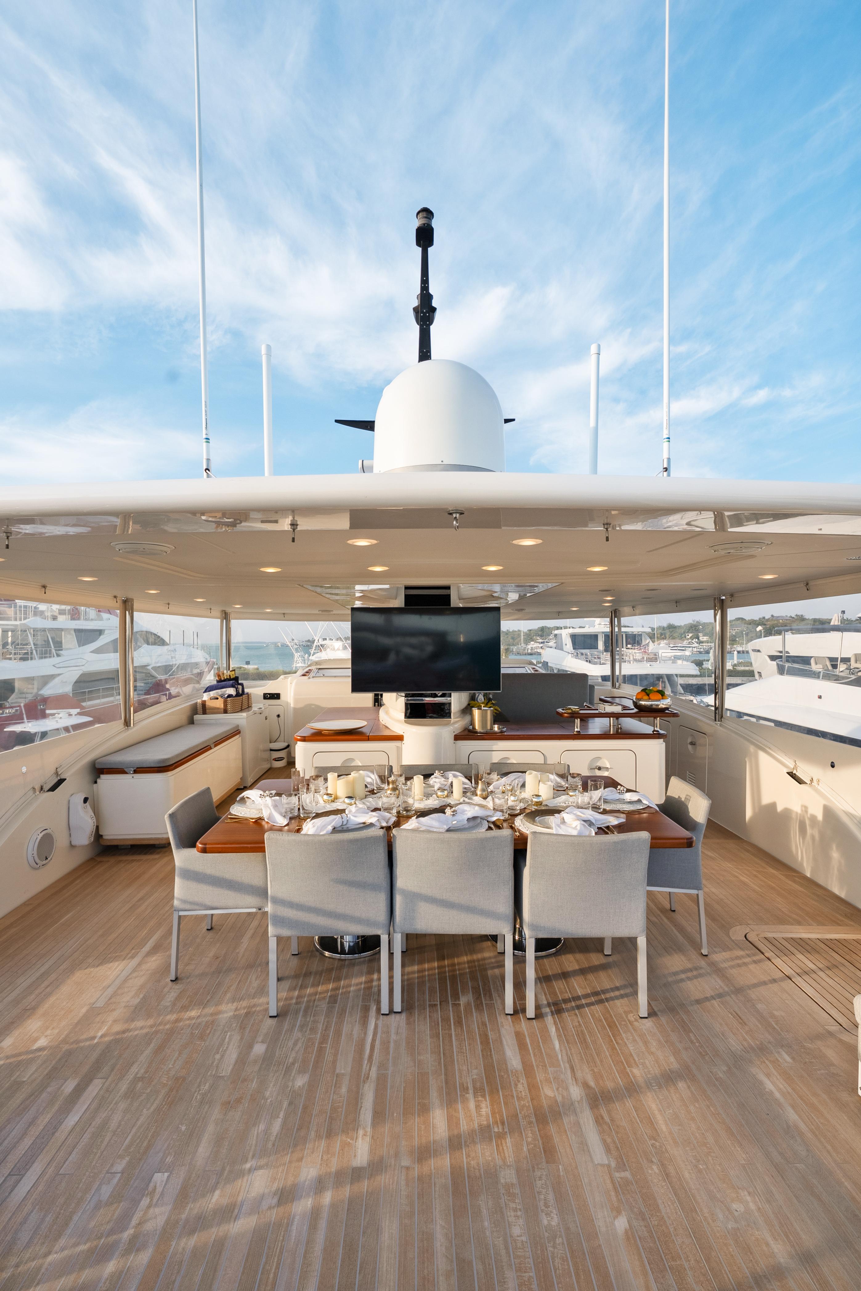 Luxurious 2012 Sanlorenzo SD92 yacht deck with elegant dining setup and panoramic views.