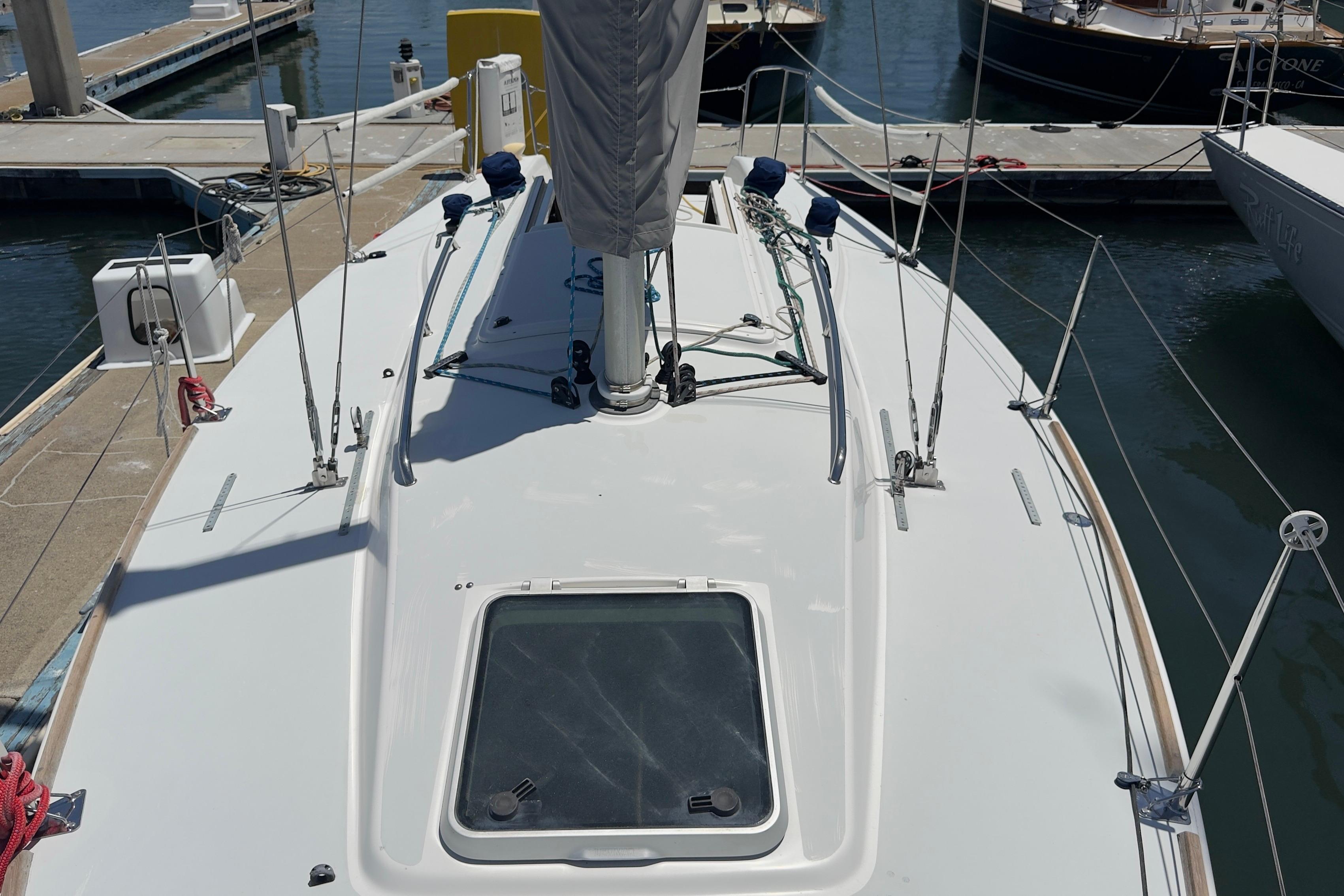 1994 J Boats J/92 sailboat docked at marina, showcasing deck and rigging.