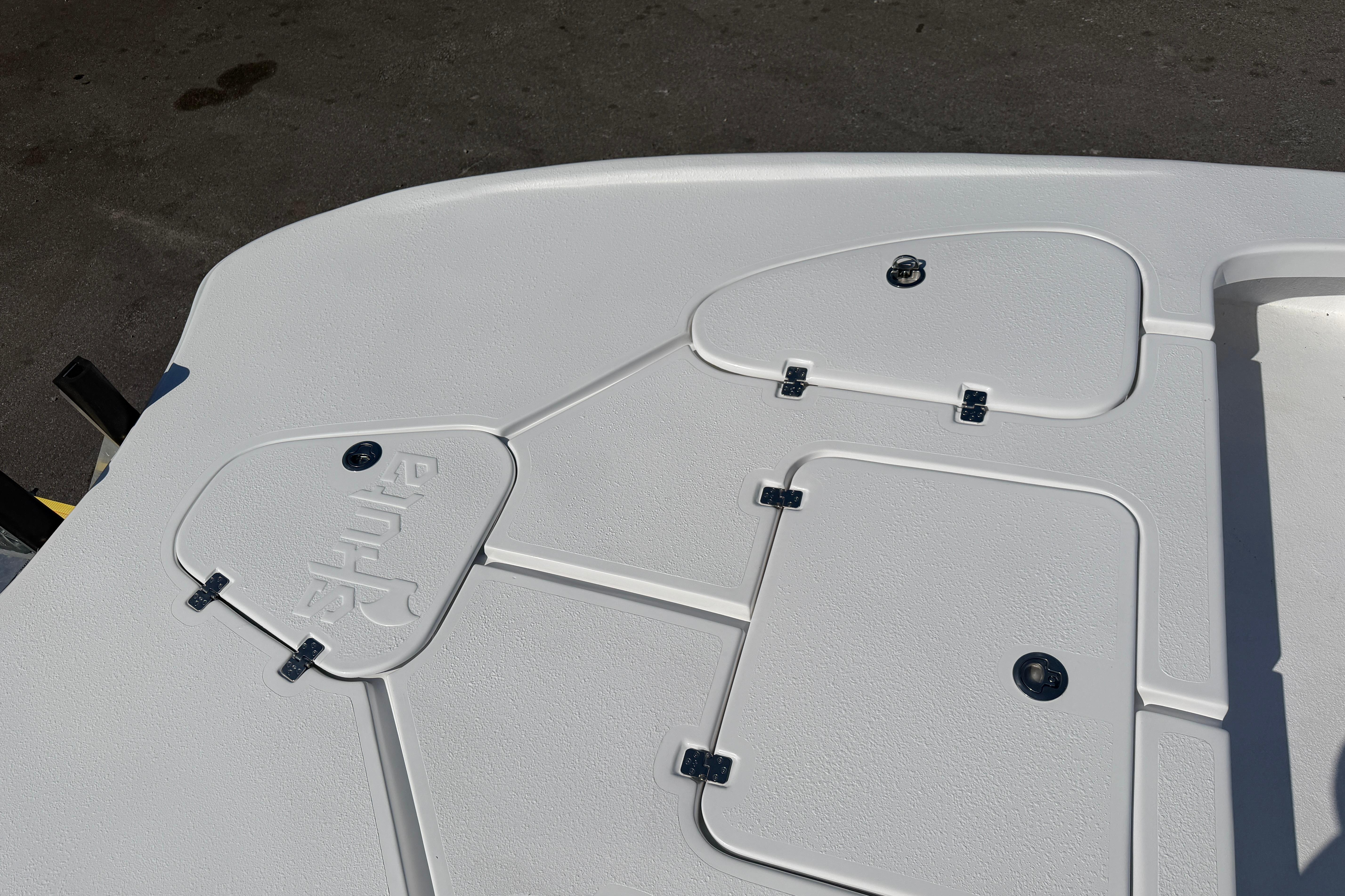 Deck of 2026 Skuta 24 Cat boat with storage compartments.