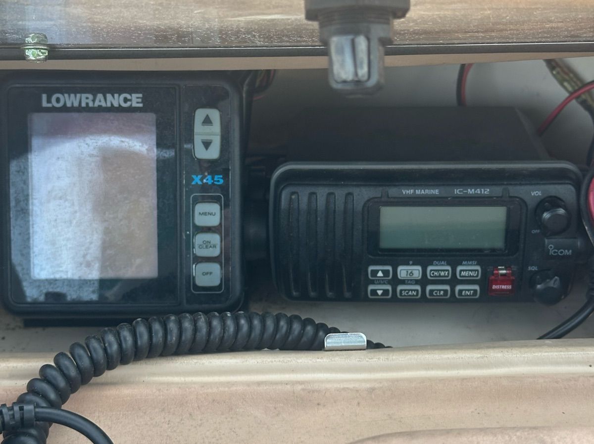 Electronic devices on a boat, including a Lowrance X45 and a VHF marine radio.