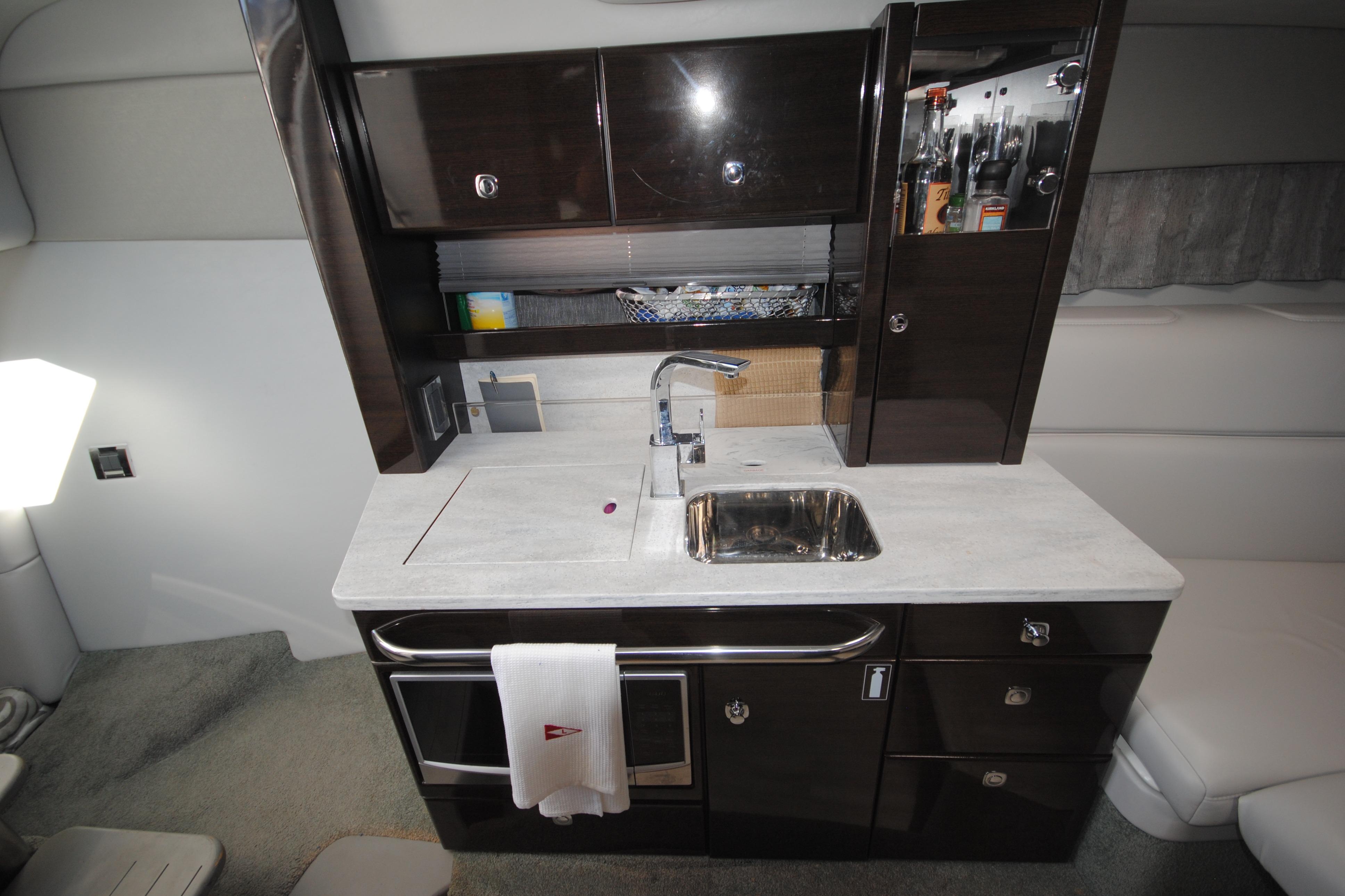 2017 Formula 370 Super Sport yacht interior kitchen with sink and storage cabinets.