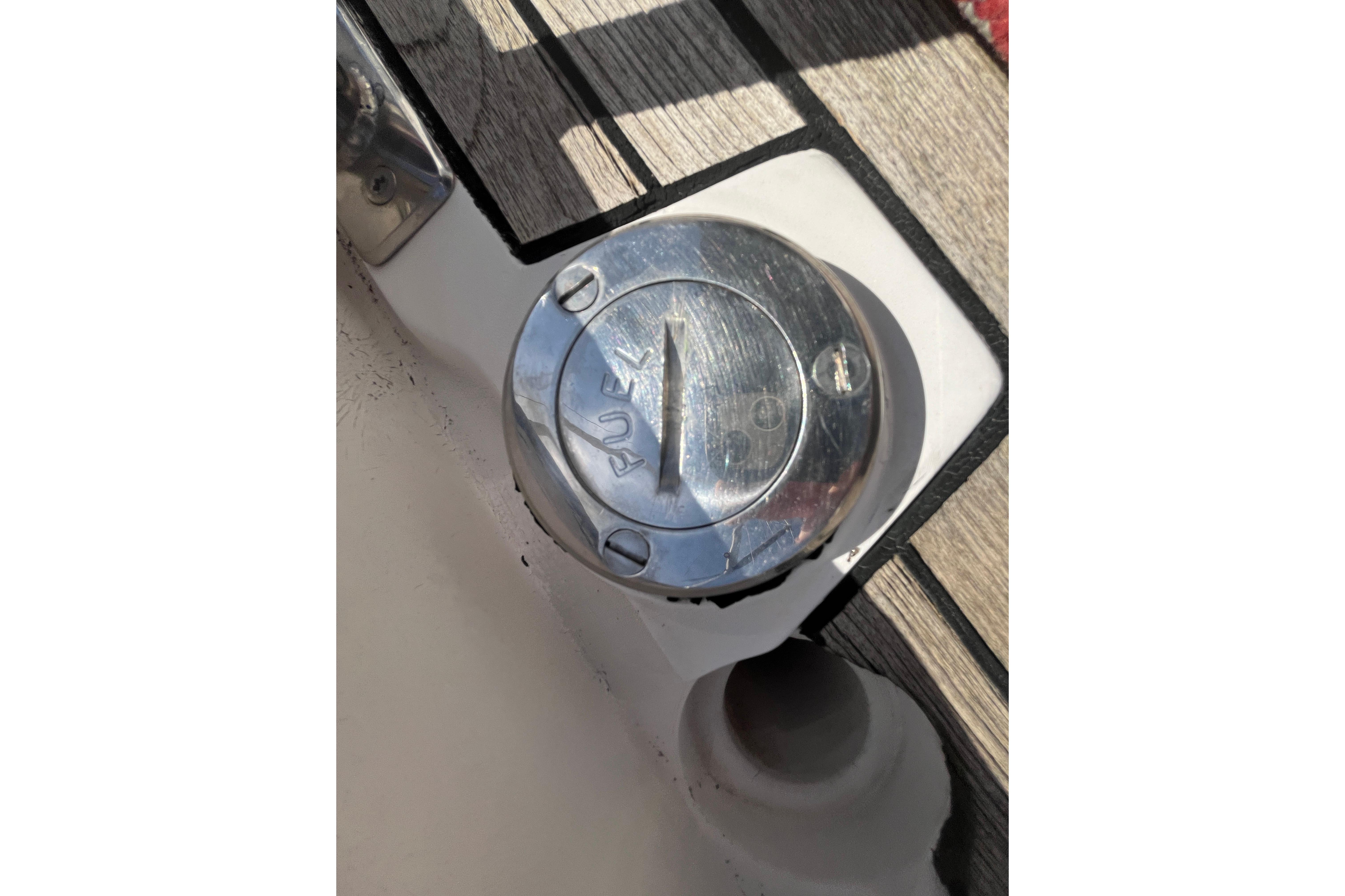 Fuel cap on 1995 Belliure 41 yacht deck, featuring metallic finish and wood trim.