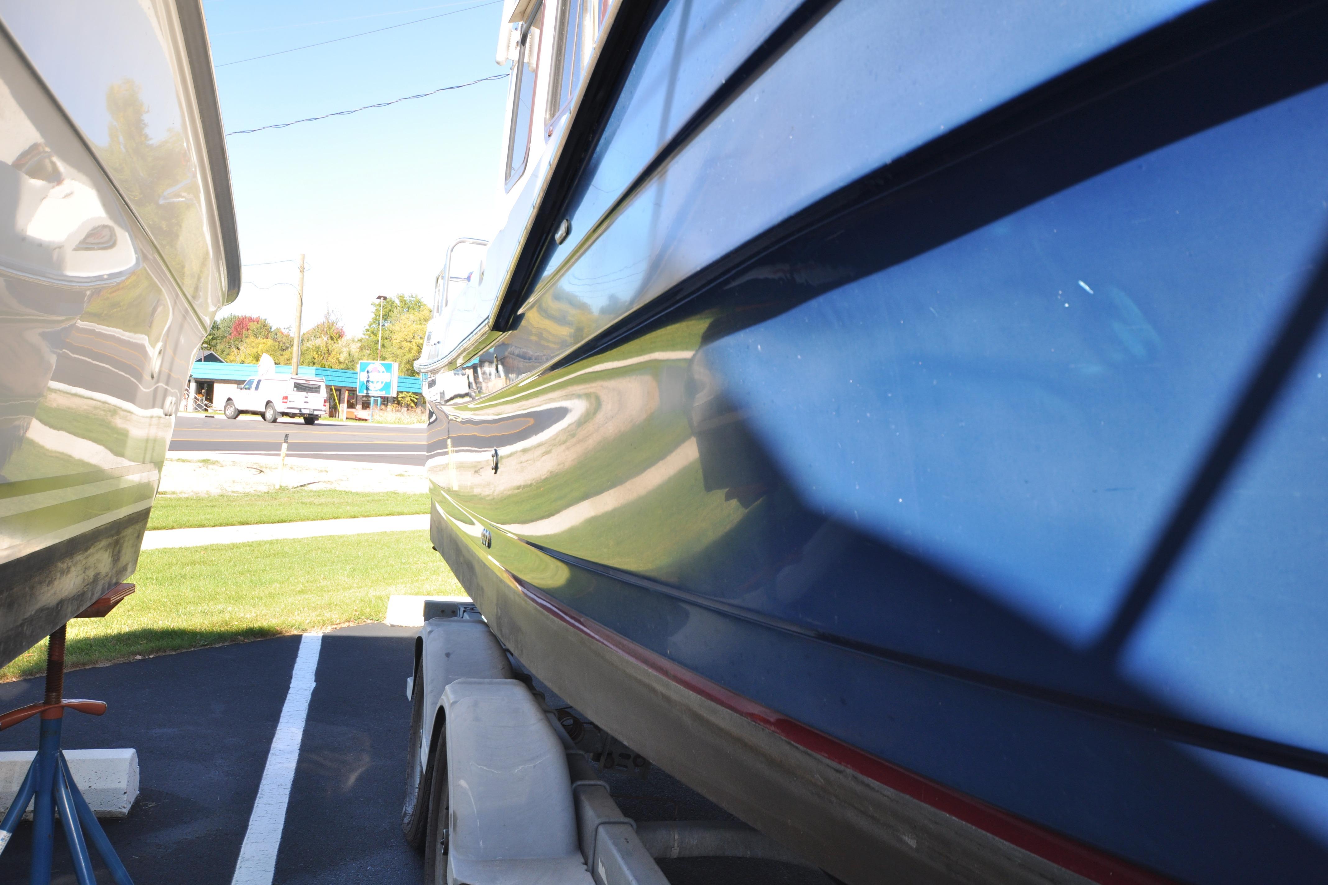 2007 Ranger Tug R-25 boat on trailer, parked outdoors, side view.