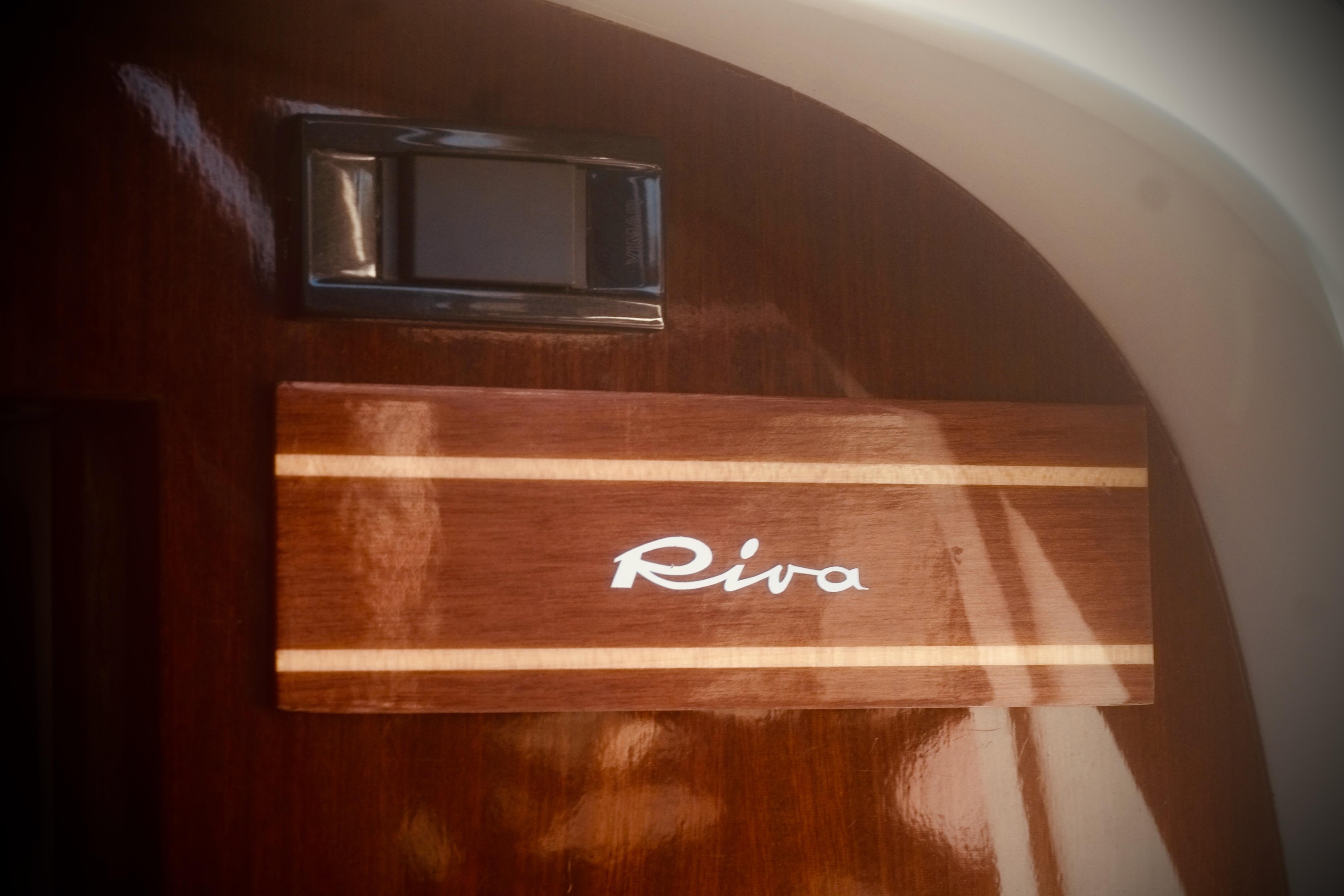 Riva Aquariva 33, 2003 model, elegant wooden panel with logo detail.
