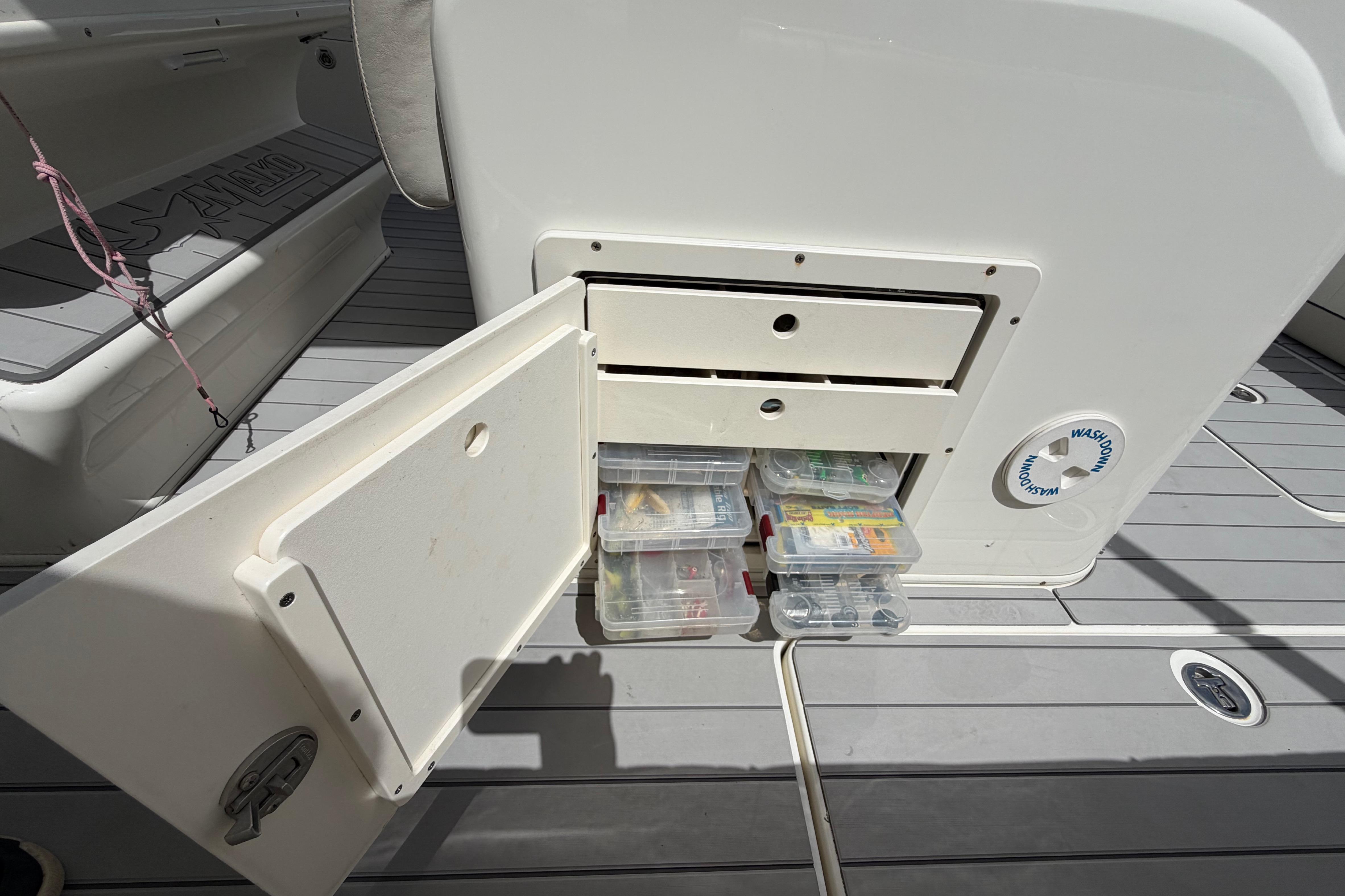 Storage compartment on a 2017 Mako 284 Center Console boat with tackle boxes.