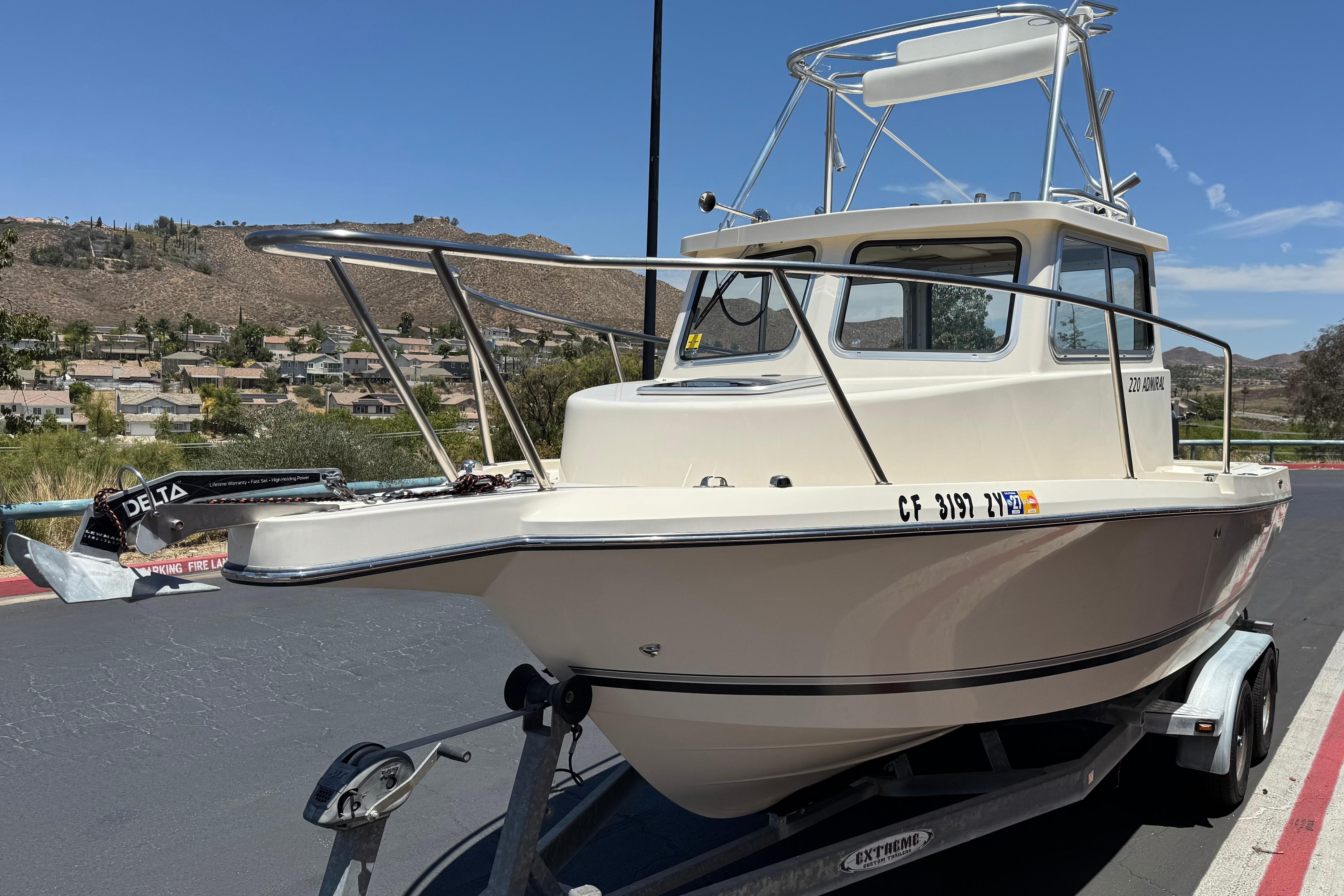 2017 Defiance Admiral 220 EX boat on trailer, parked outdoors under clear sky.