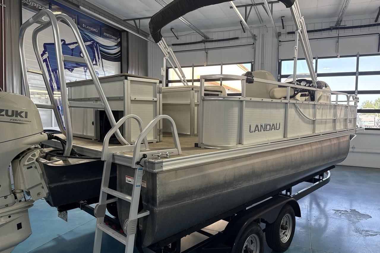 2018 Landau Alure 212 Fish pontoon boat in a showroom with Suzuki outboard motor.