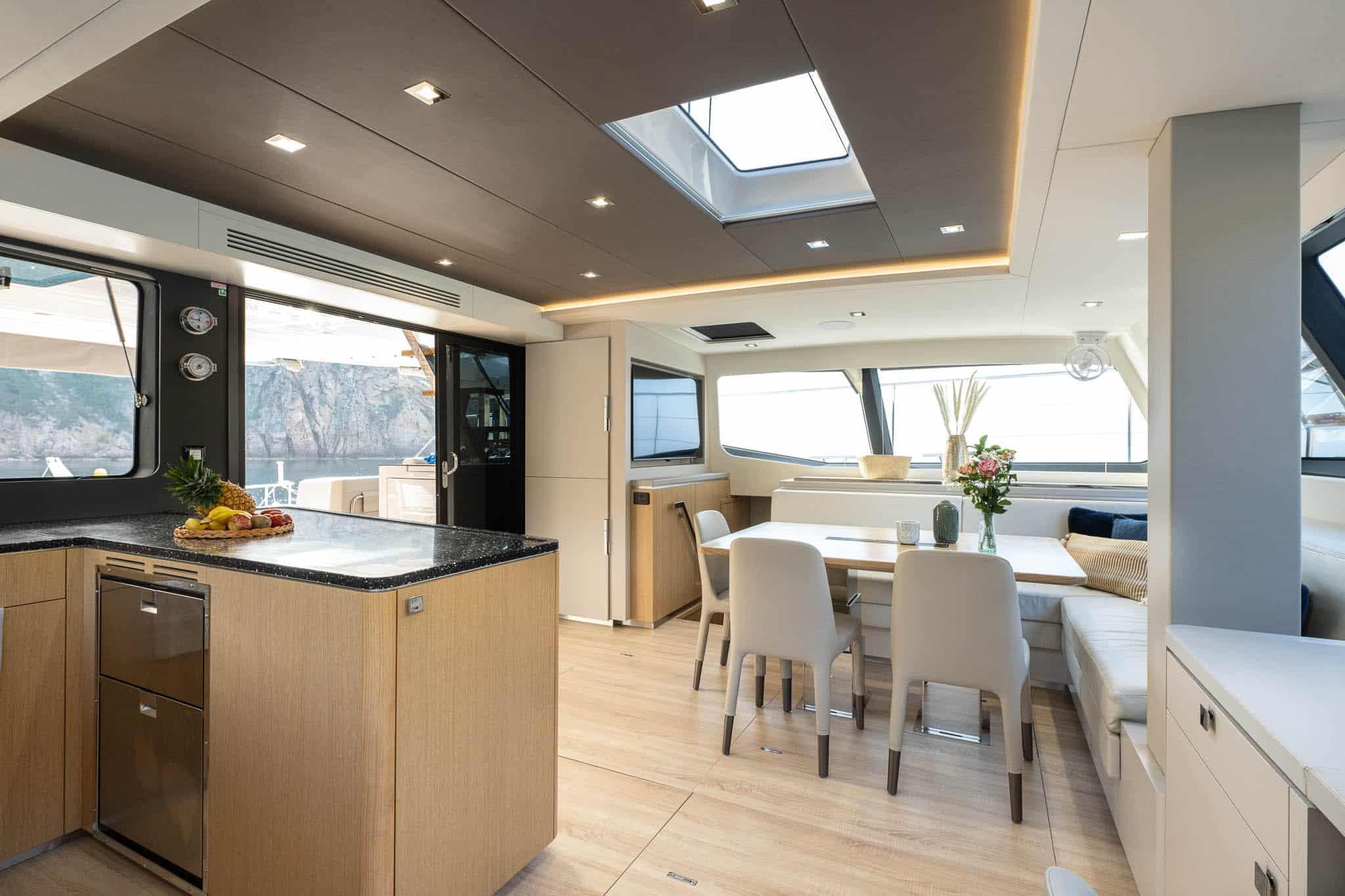 Luxurious interior of 2025 Privilege Signature 580 yacht with modern dining area and kitchen.