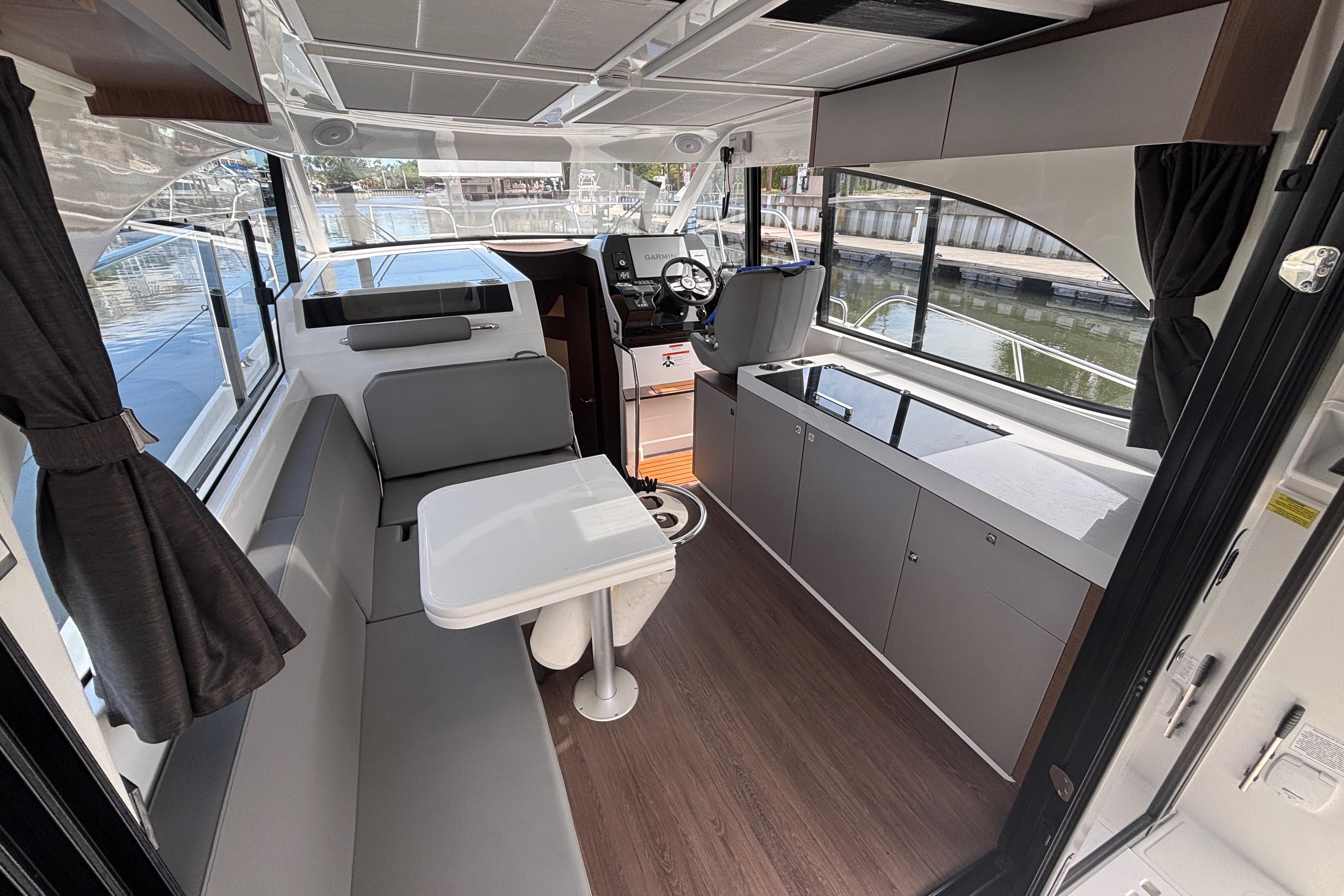 Interior of 2024 Beneteau Antares 11, featuring modern seating and helm station.