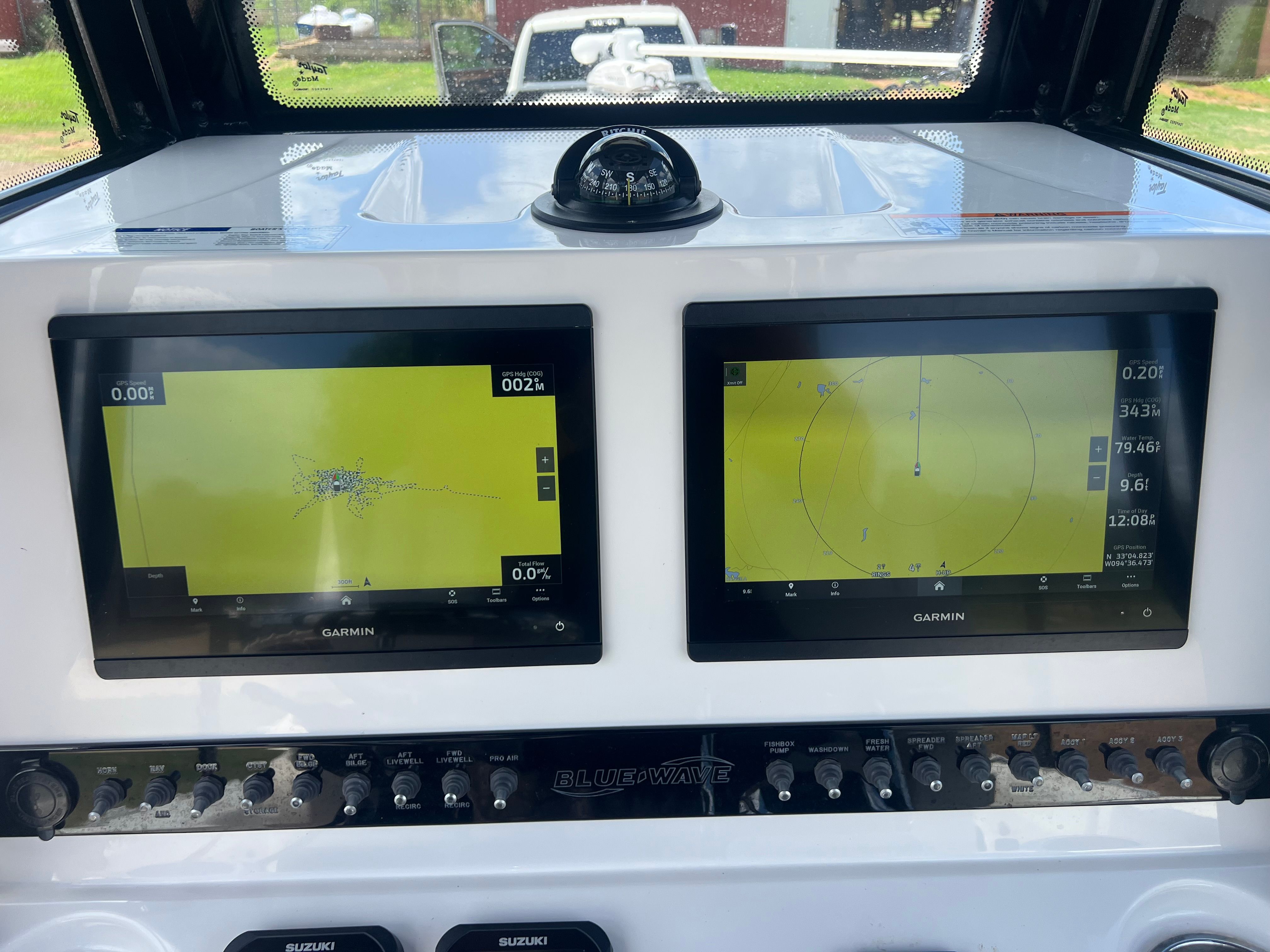 The image shows the dashboard of a Blue Wave 2800 Makaira boat with two Garmin screens.