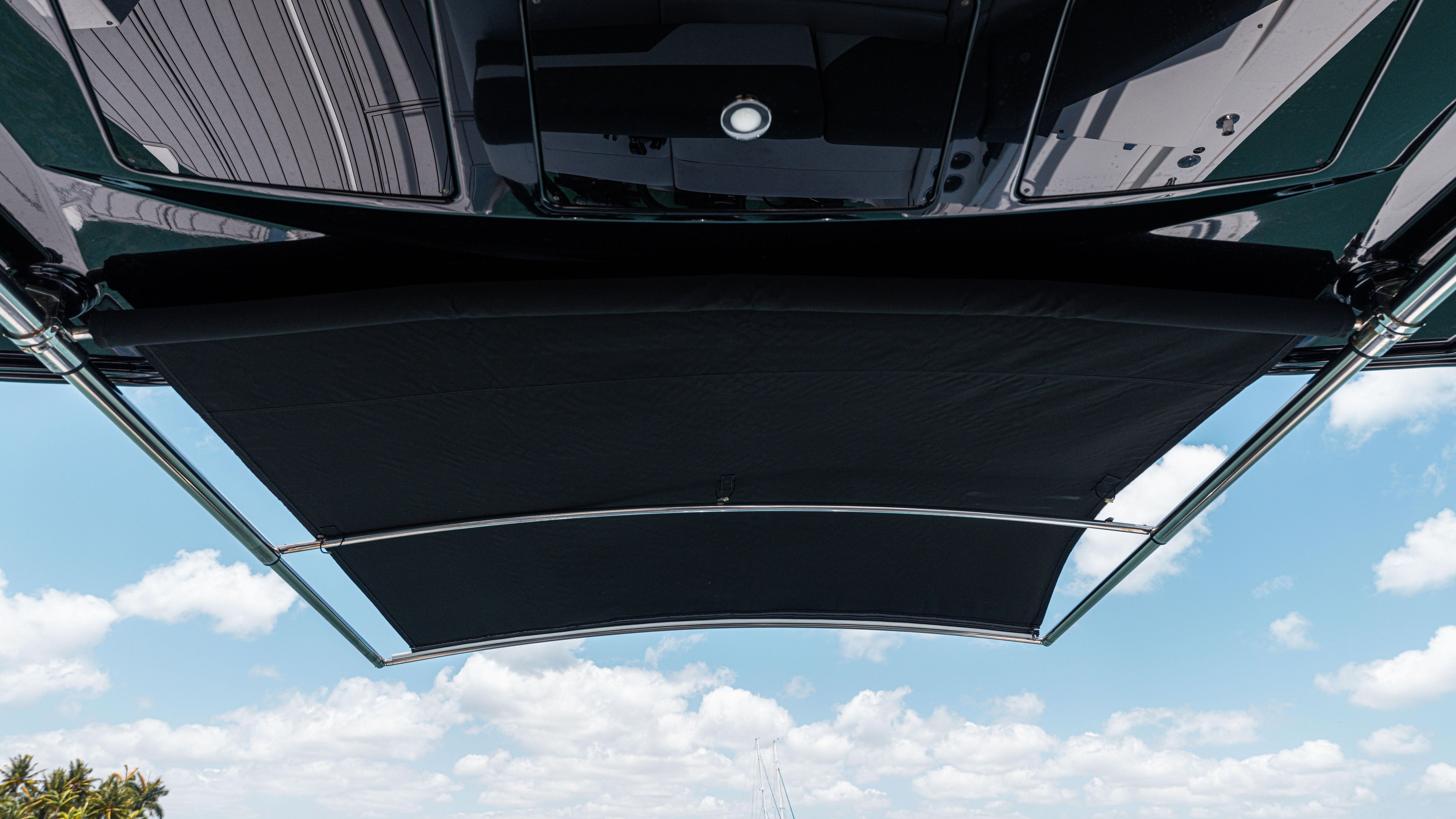 2020 Cruisers Yachts 38 GLS OB canopy against a blue sky with clouds.