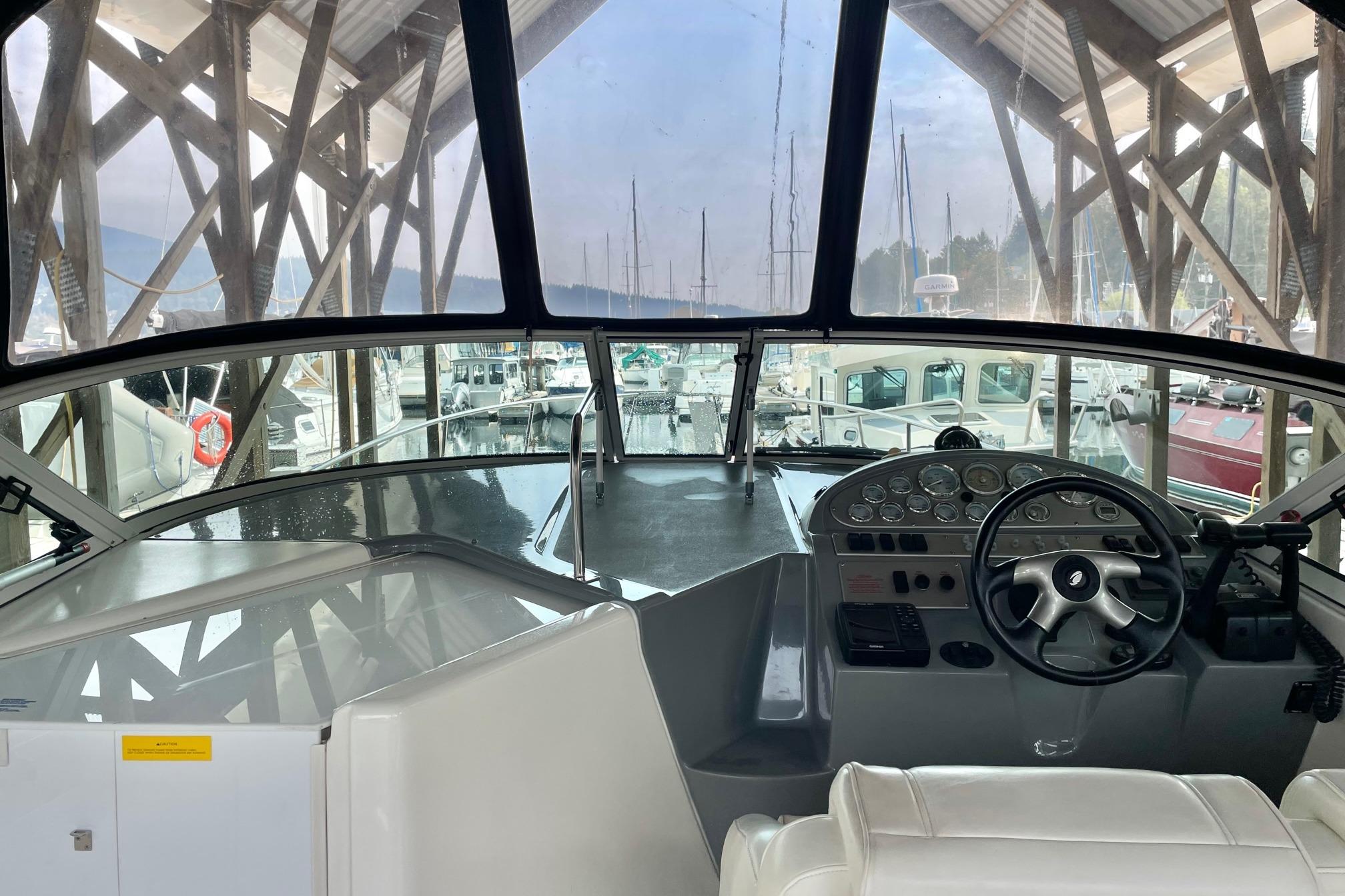 2005 Cruisers Yachts 280 CXi Express helm with marina view, featuring steering wheel and controls.