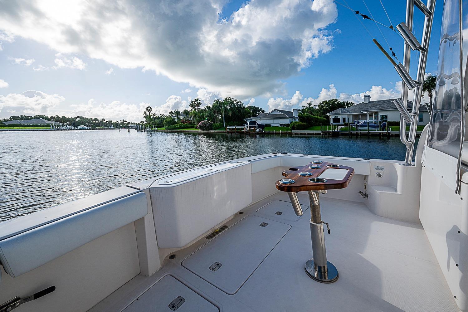 2008 Bertram 360 boat deck overlooking serene waterfront and residential area under a partly cloudy sky.