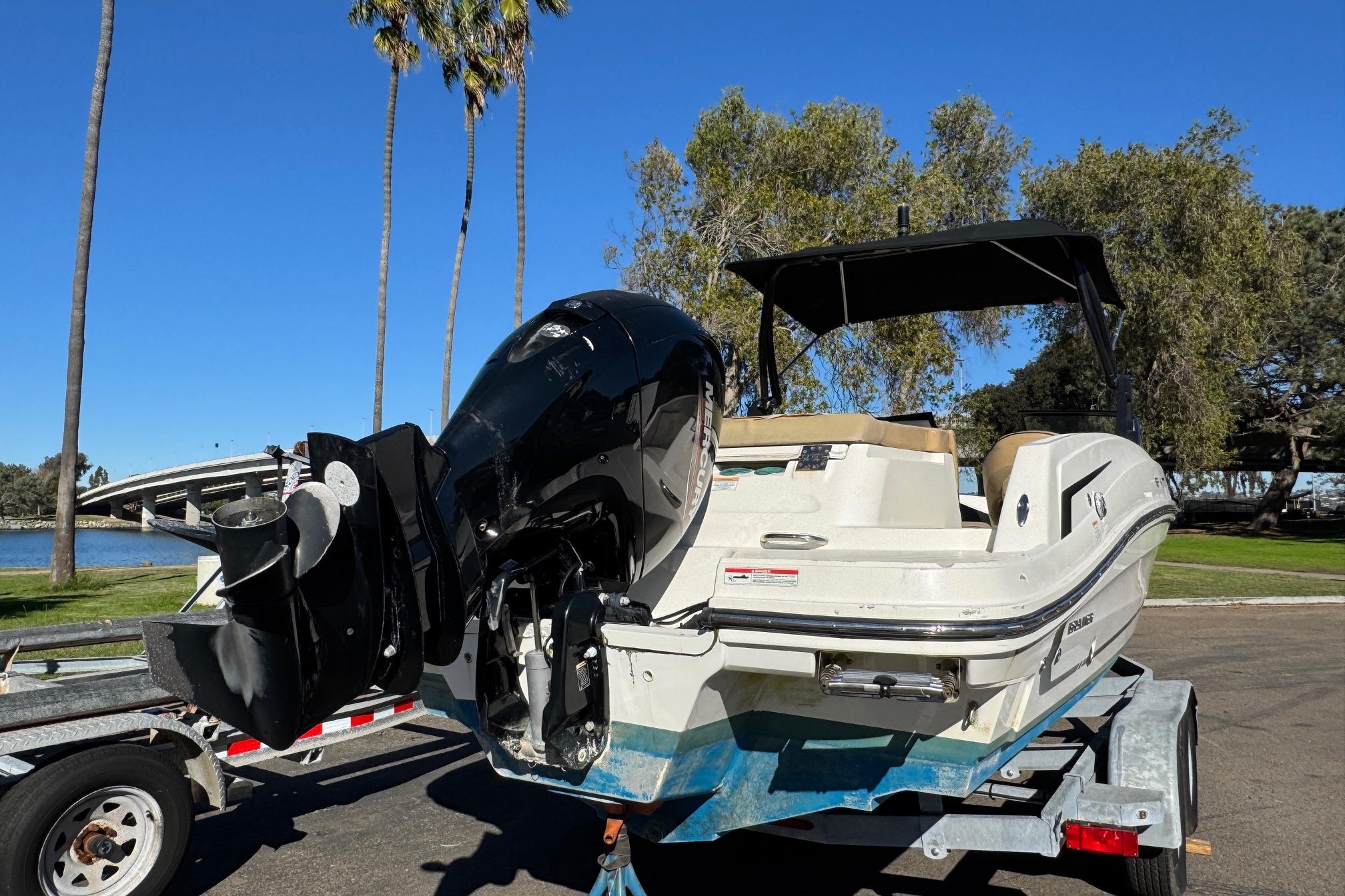 2022 Bayliner VR6 Bowrider OB on trailer, parked near palm trees and water.