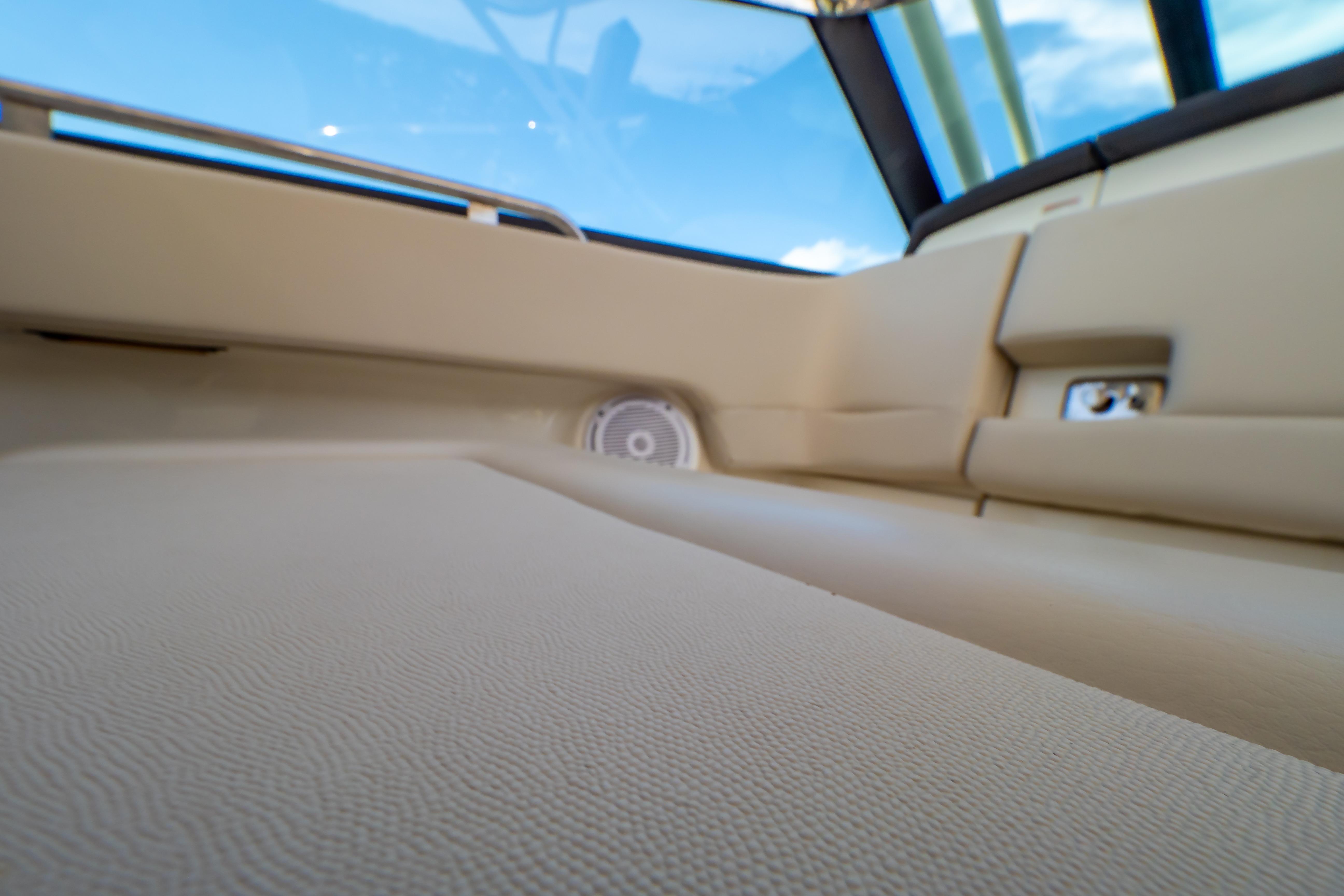 Interior view of 2019 Boston Whaler 270 Vantage boat, featuring beige upholstery and speaker.