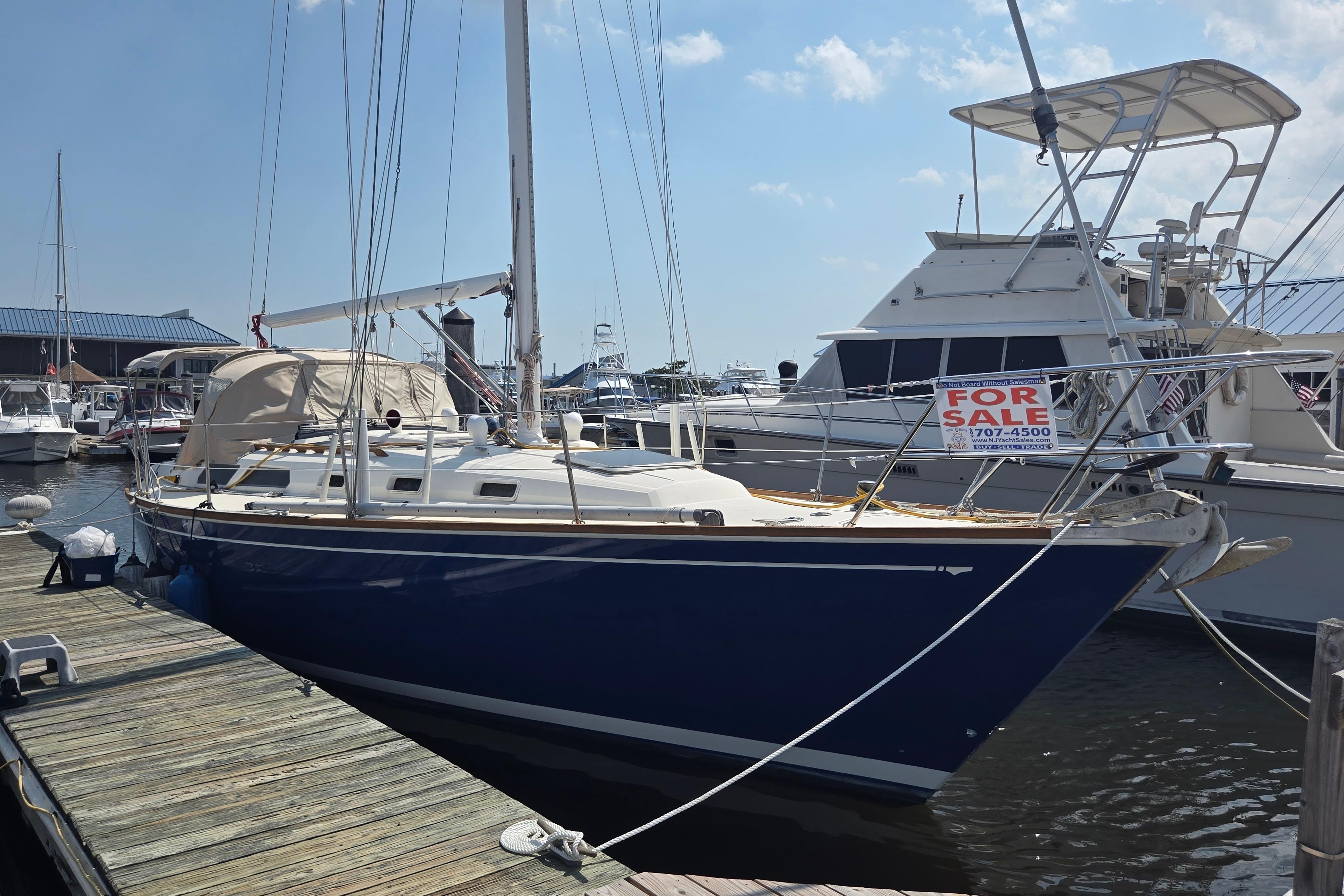 1988 Sabre 38 sailboat docked, blue hull, for sale sign visible.