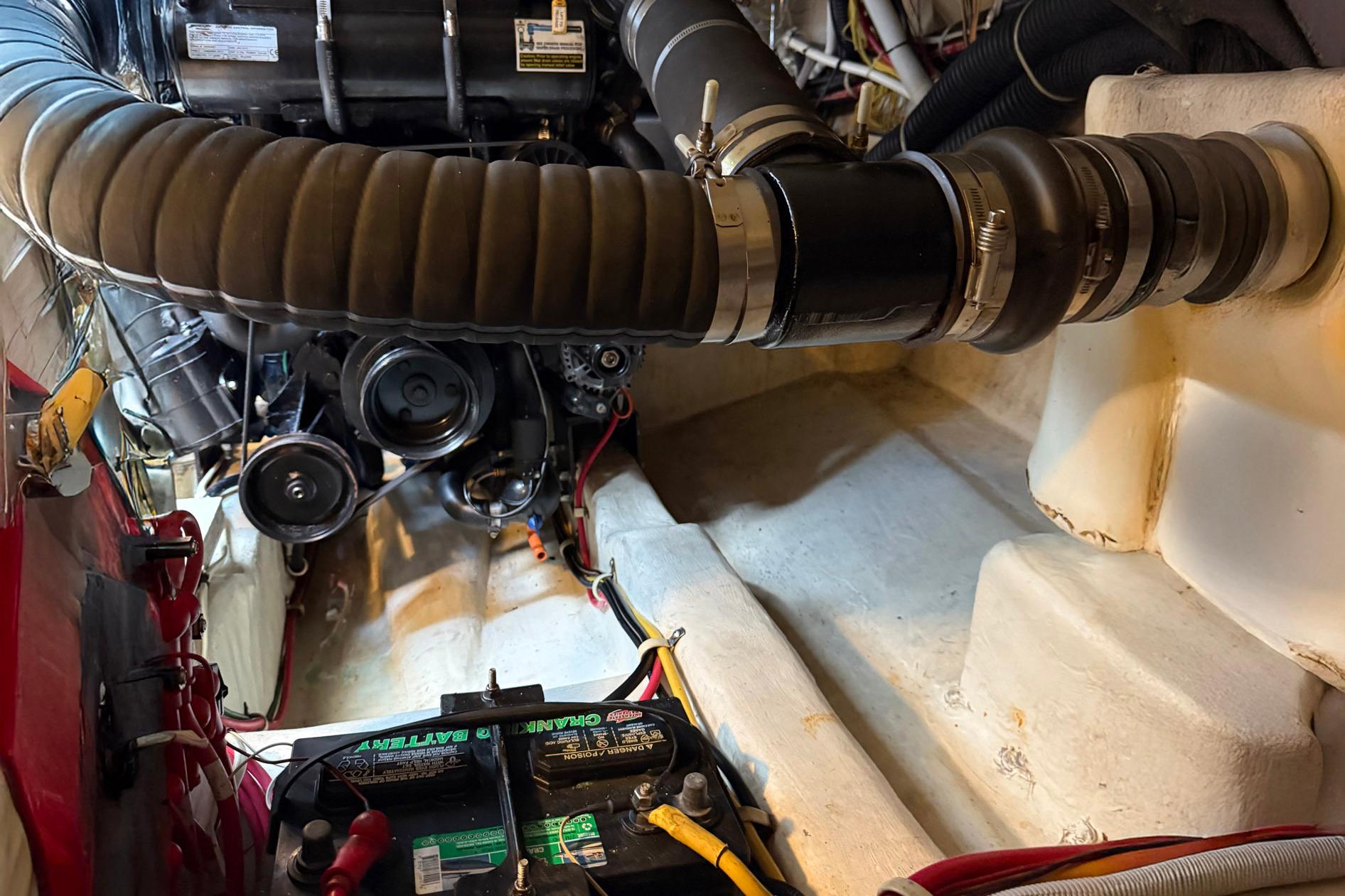 Engine compartment of a 2013 Carver C34 boat, featuring battery and mechanical components.