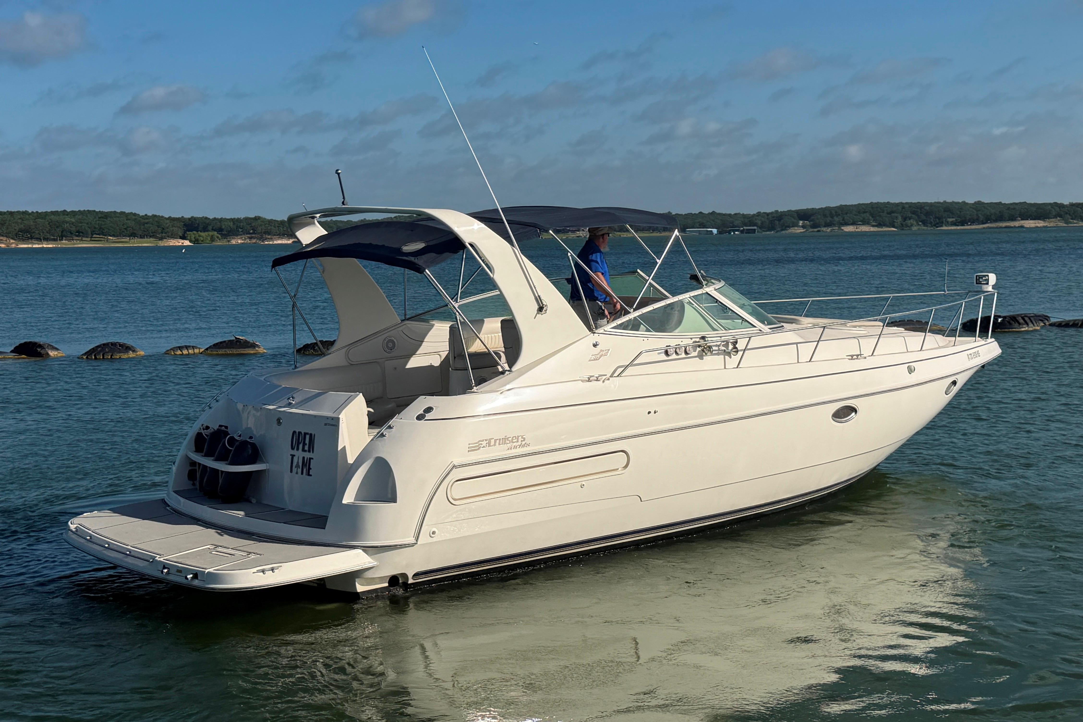 1997 Cruisers 3575 yacht on calm water, featuring sleek design and spacious deck.