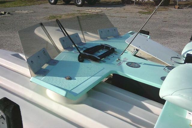 2021 CraigCat E2 Elite boat with turquoise deck and windshield, parked on gravel.