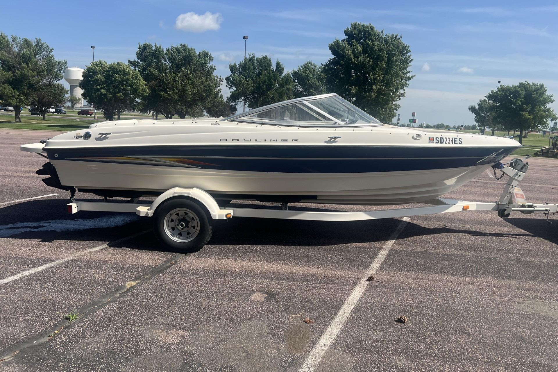 2005 Bayliner 205 Bowrider on trailer in sunny parking lot.
