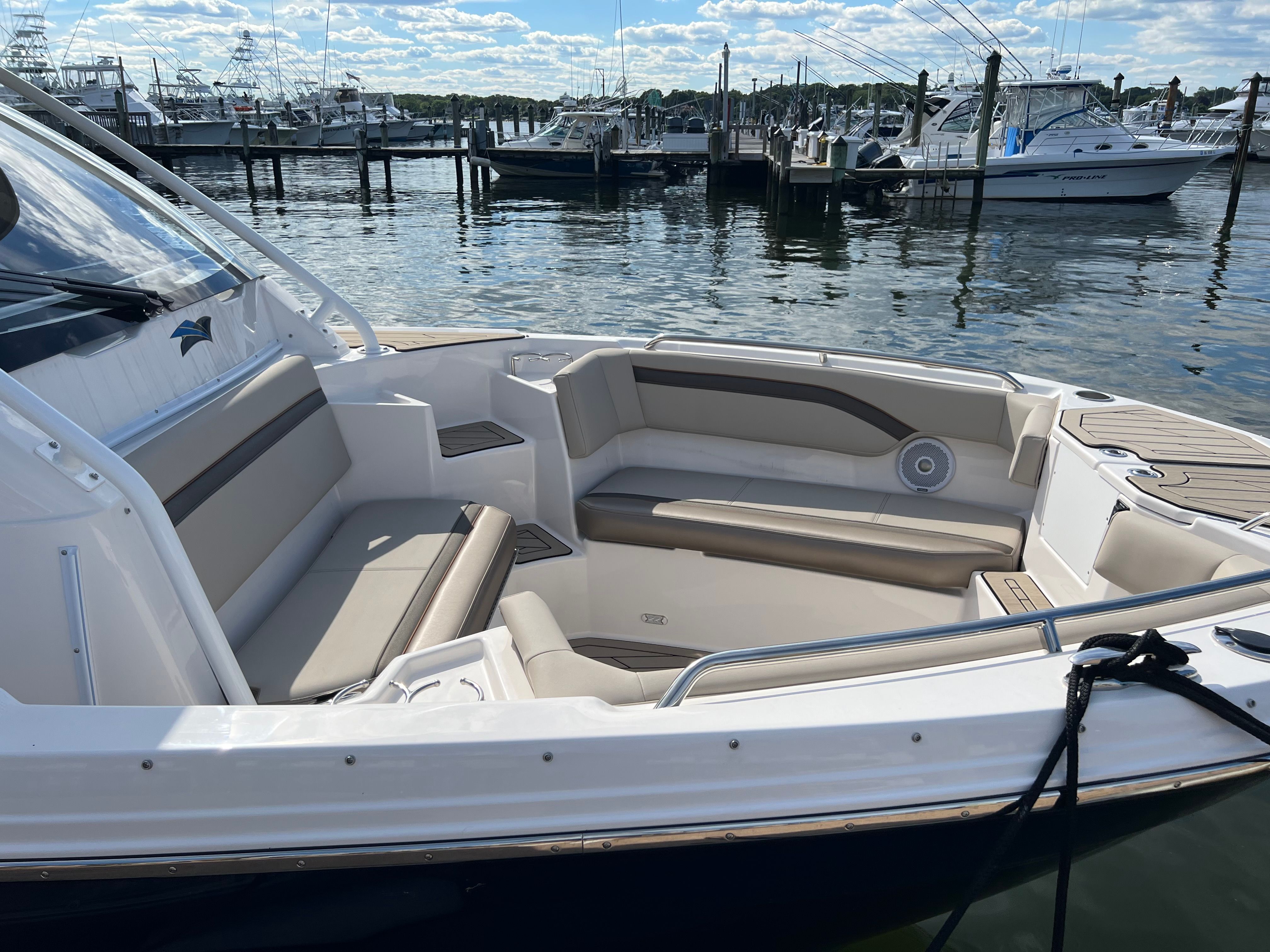 The image shows the cockpit of a 2022 Cutwater C-24 CW boat at a marina.