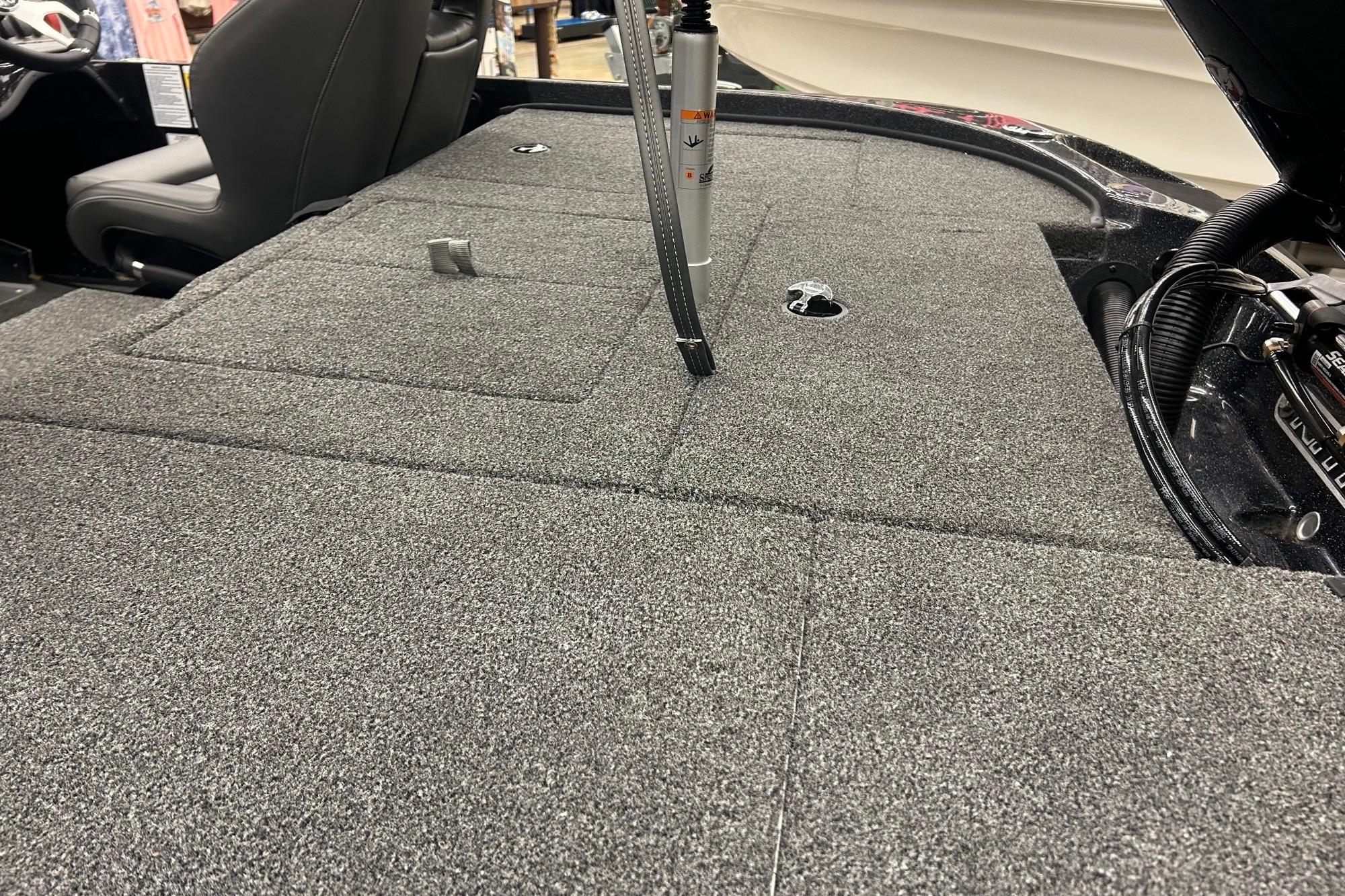 Carpeted deck of a 2026 Nitro Z18 Pro boat, featuring storage compartments and seating.