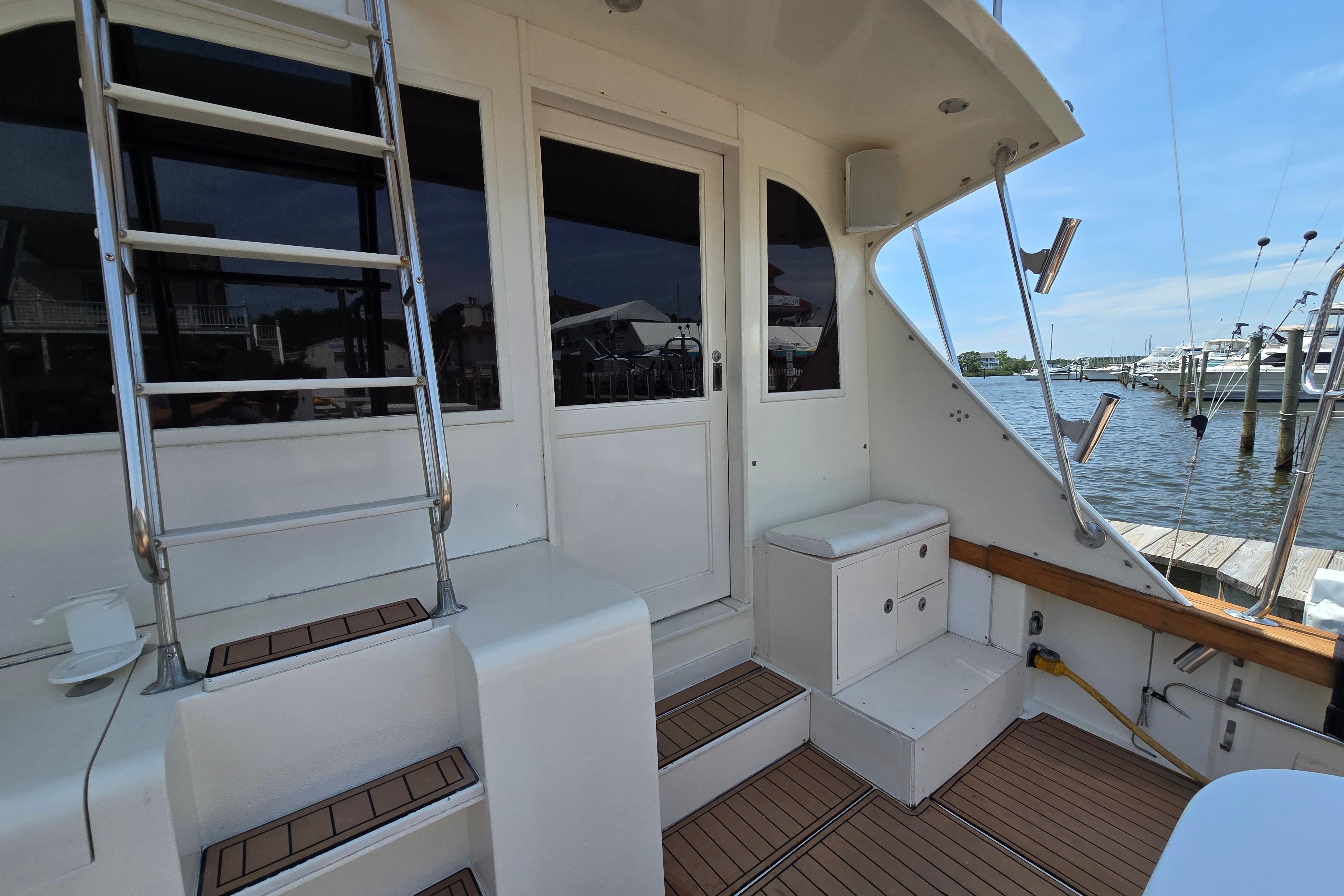 1988 Post 46 Convertible yacht deck with ladder and seating, docked by the water.