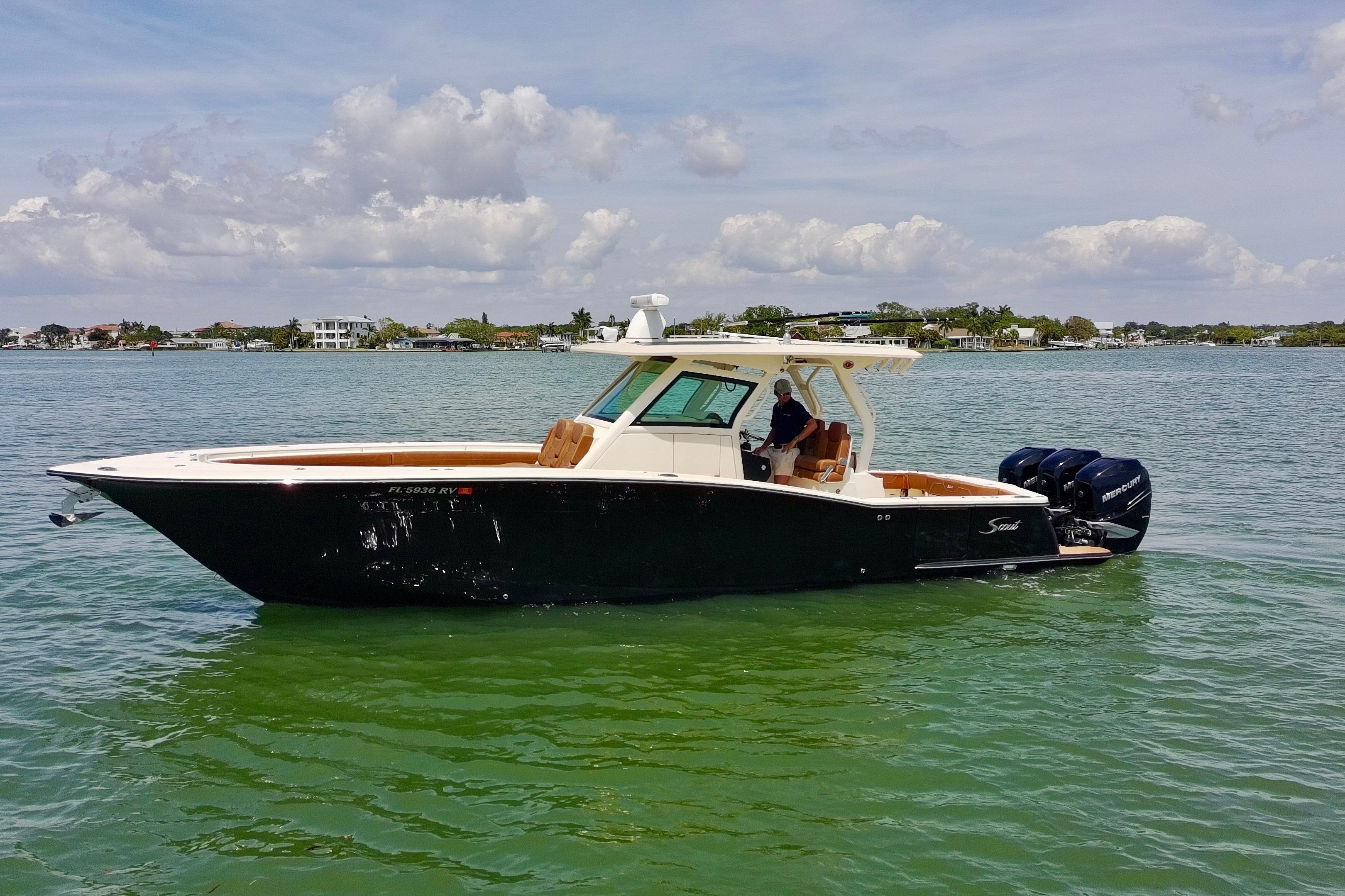 2018 Scout 355 LXF boat on calm water with clear skies.