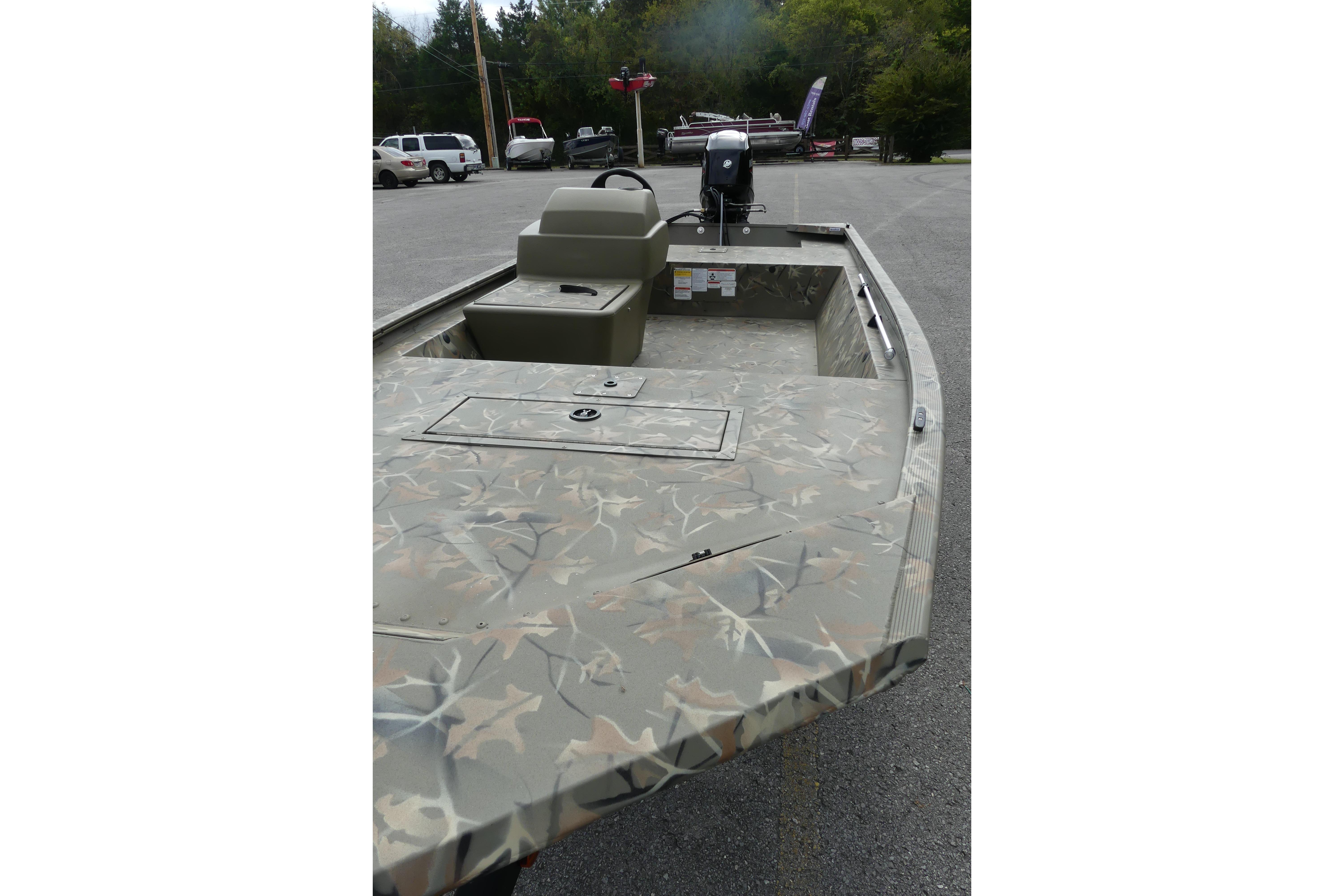 2025 Tracker Grizzly 1648 SC boat with camouflage design in a parking lot.