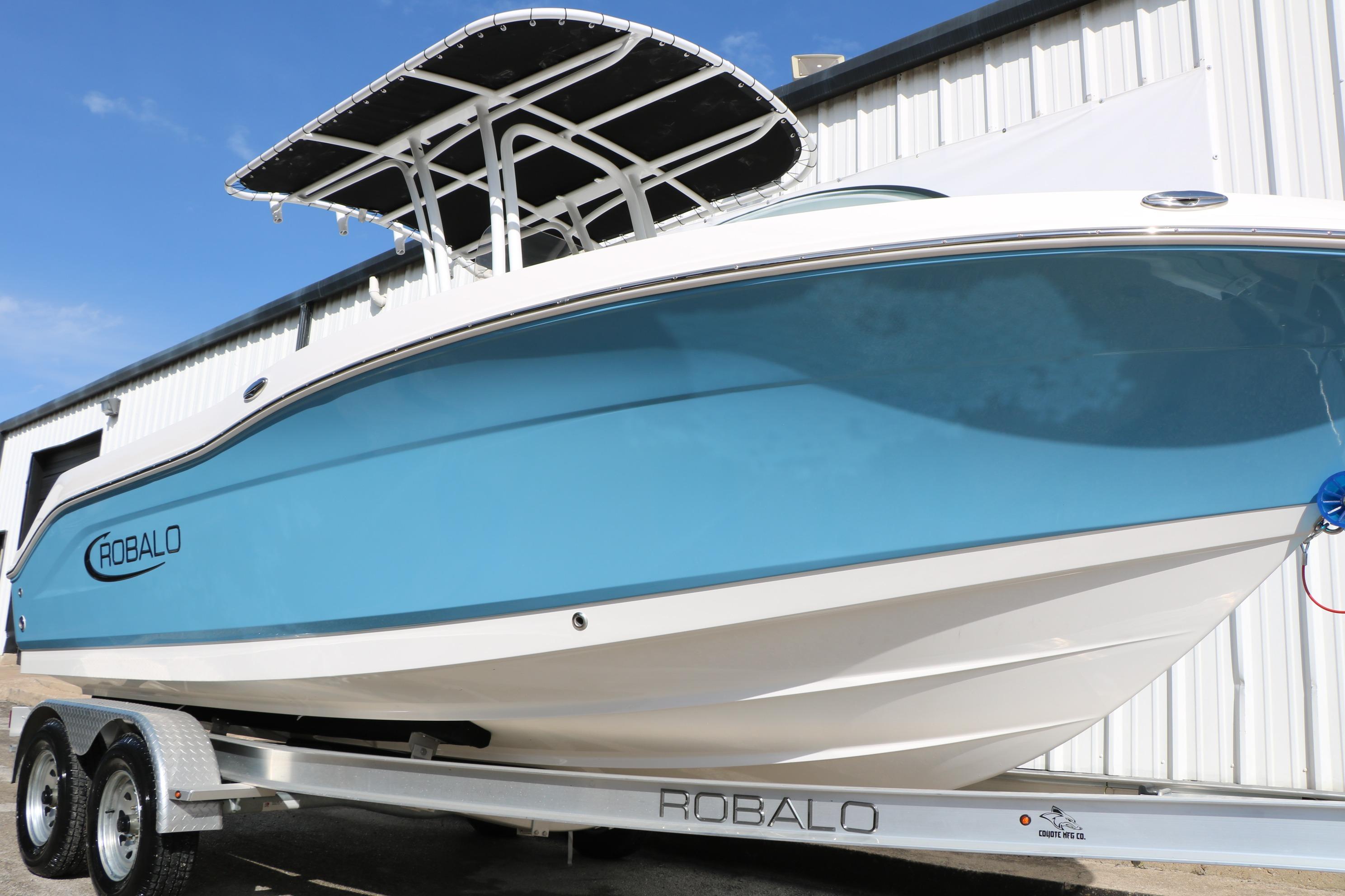 2026 Robalo R200 Center Console boat on trailer, blue hull, outdoor setting.