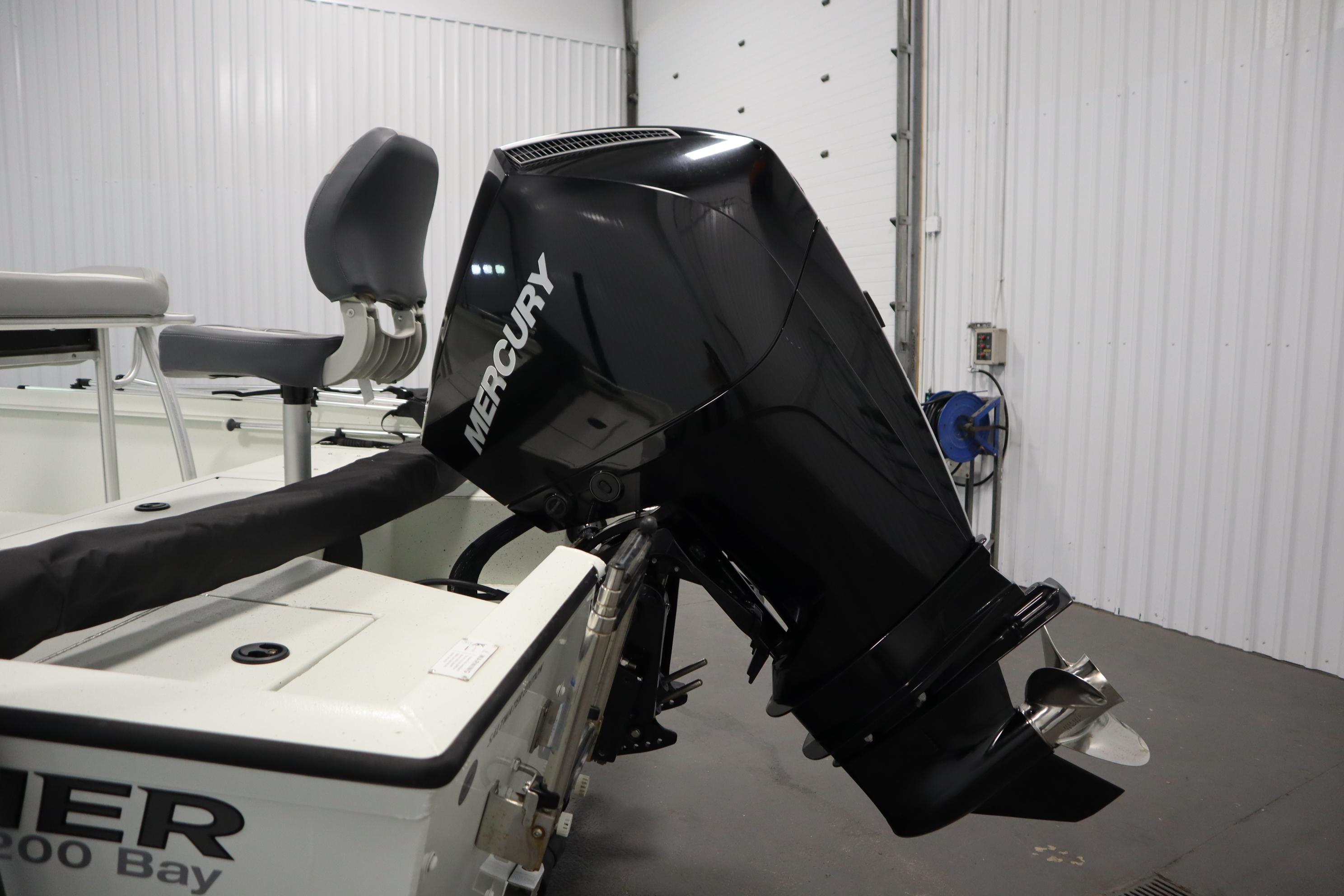 2022 Crestliner 2200 CC boat with Mercury outboard motor in a garage setting.