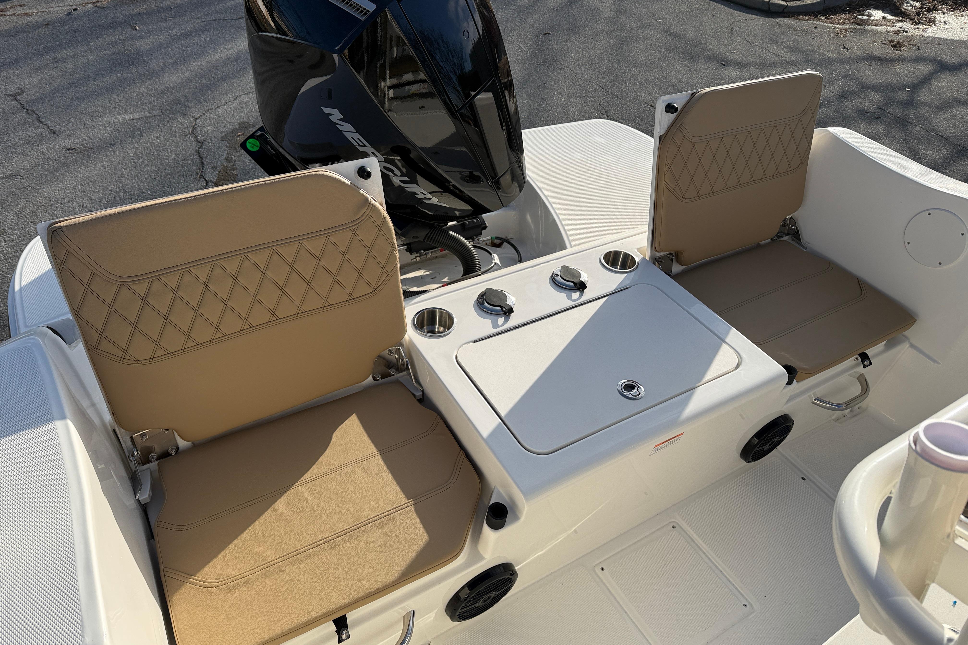 2026 Bayliner Trophy T22CC boat seating with tan cushions and storage compartment.