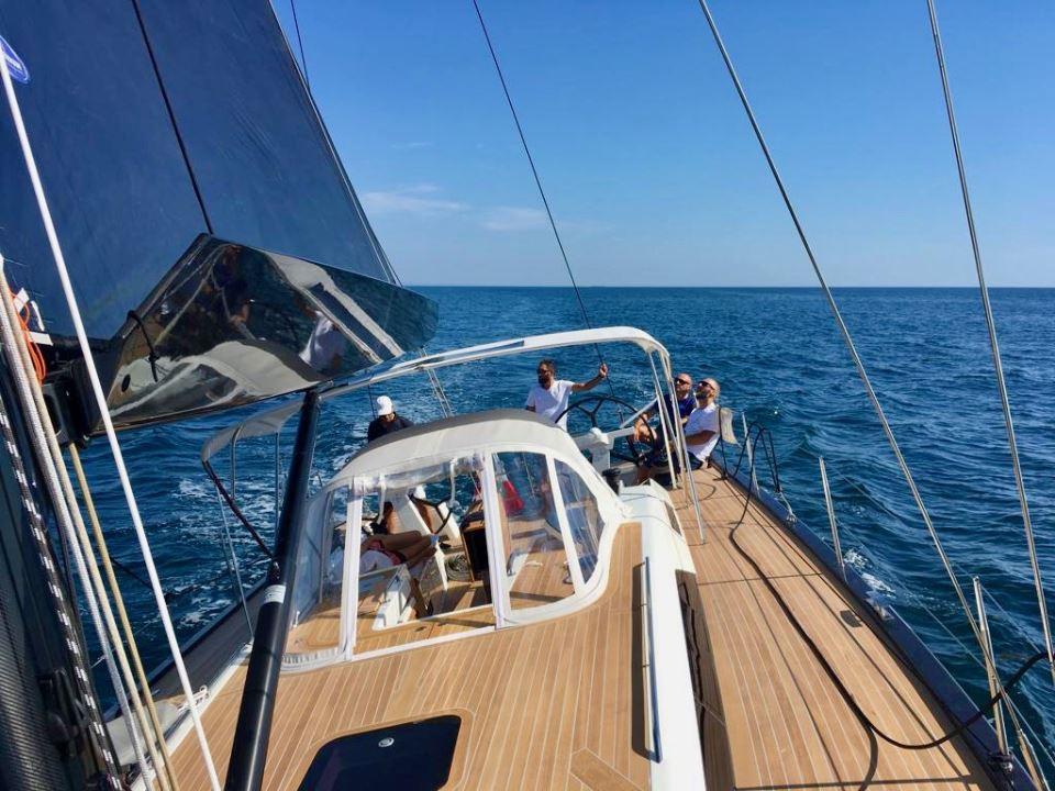 Sailing on a 2019 Solaris 50 yacht in open sea under clear blue skies.