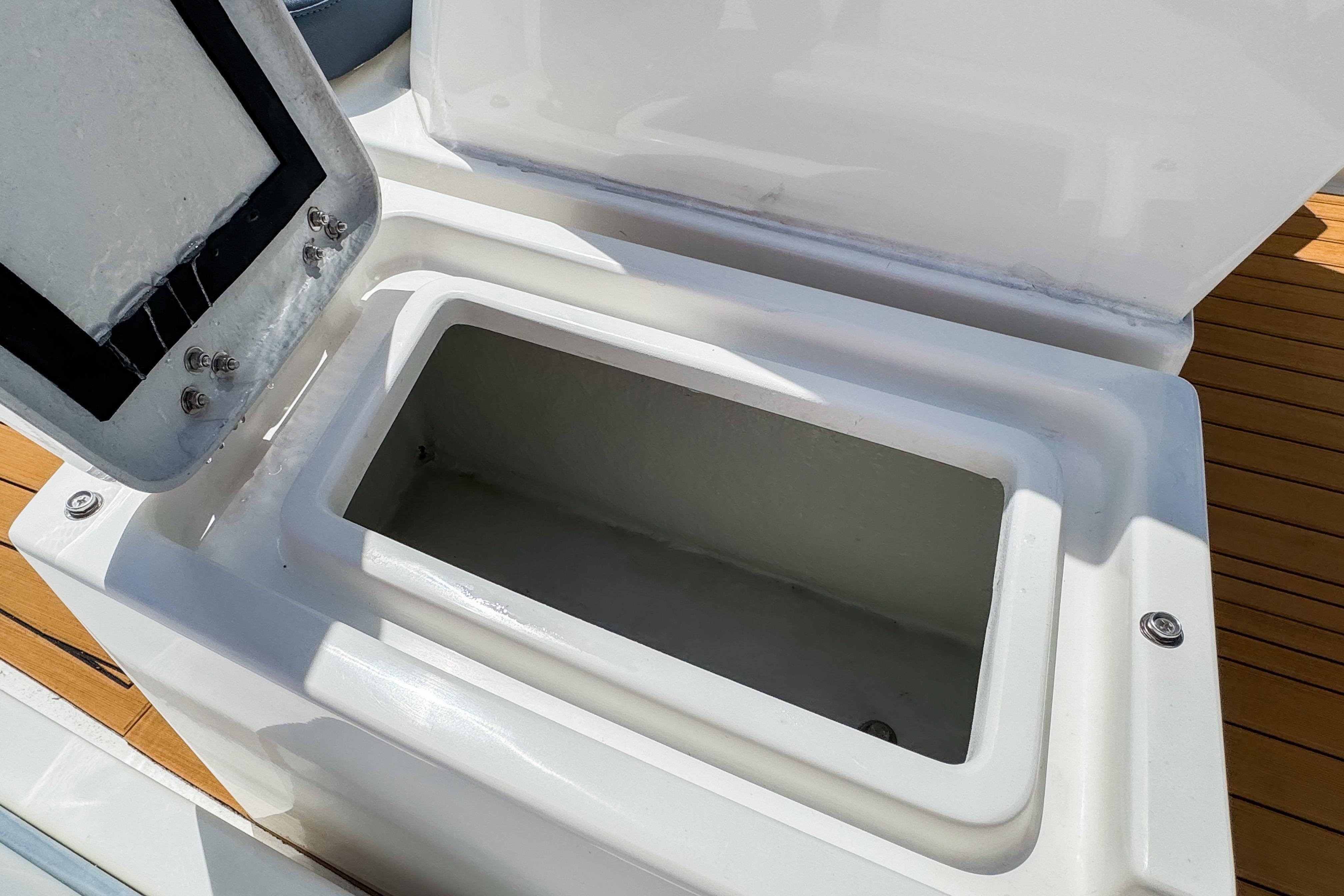 Open storage compartment on 2023 Northstar Axis 4.8 boat, featuring sleek white design.