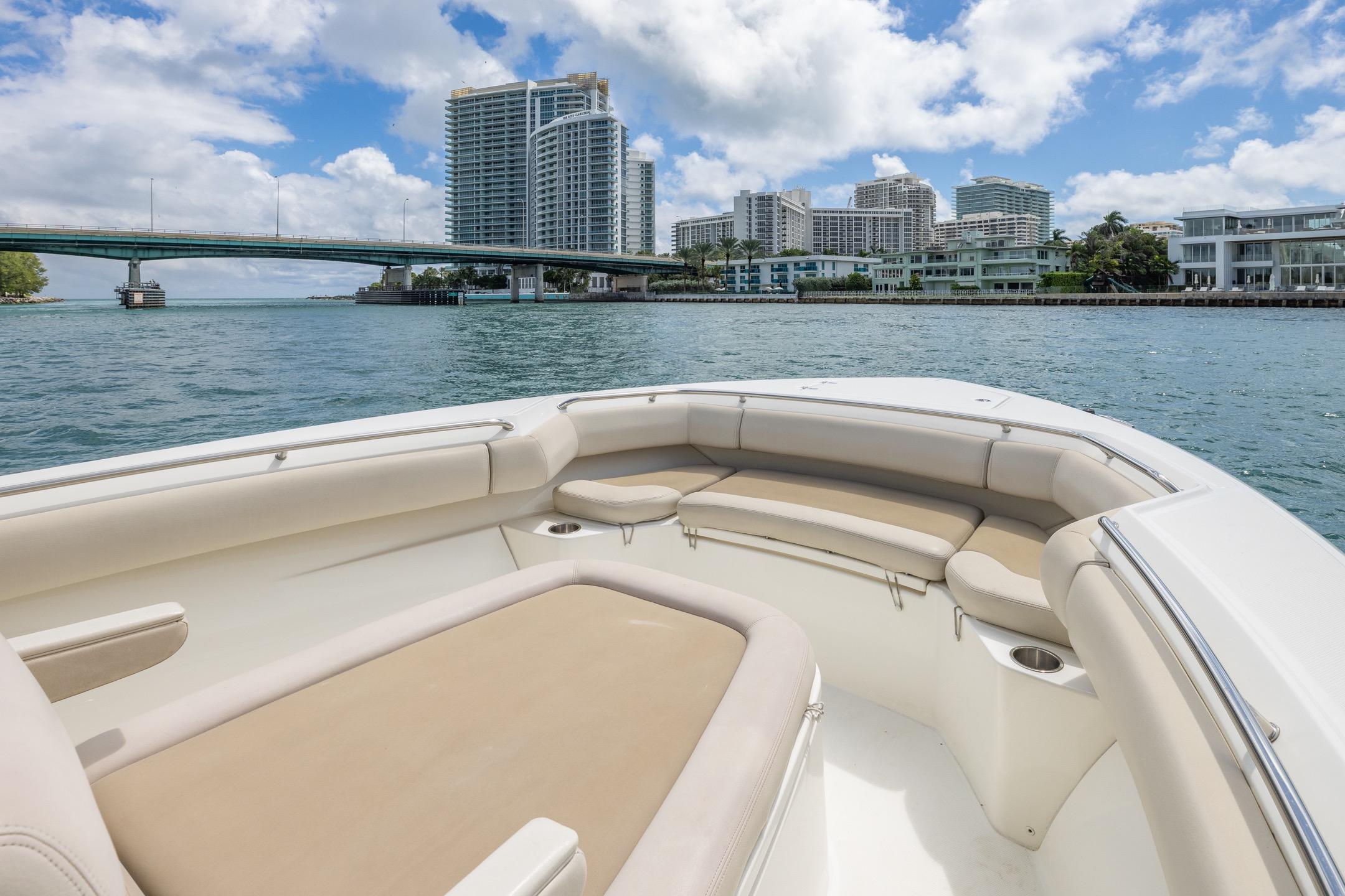 2016 Boston Whaler 280 Outrage boat on water with cityscape and bridge in background.