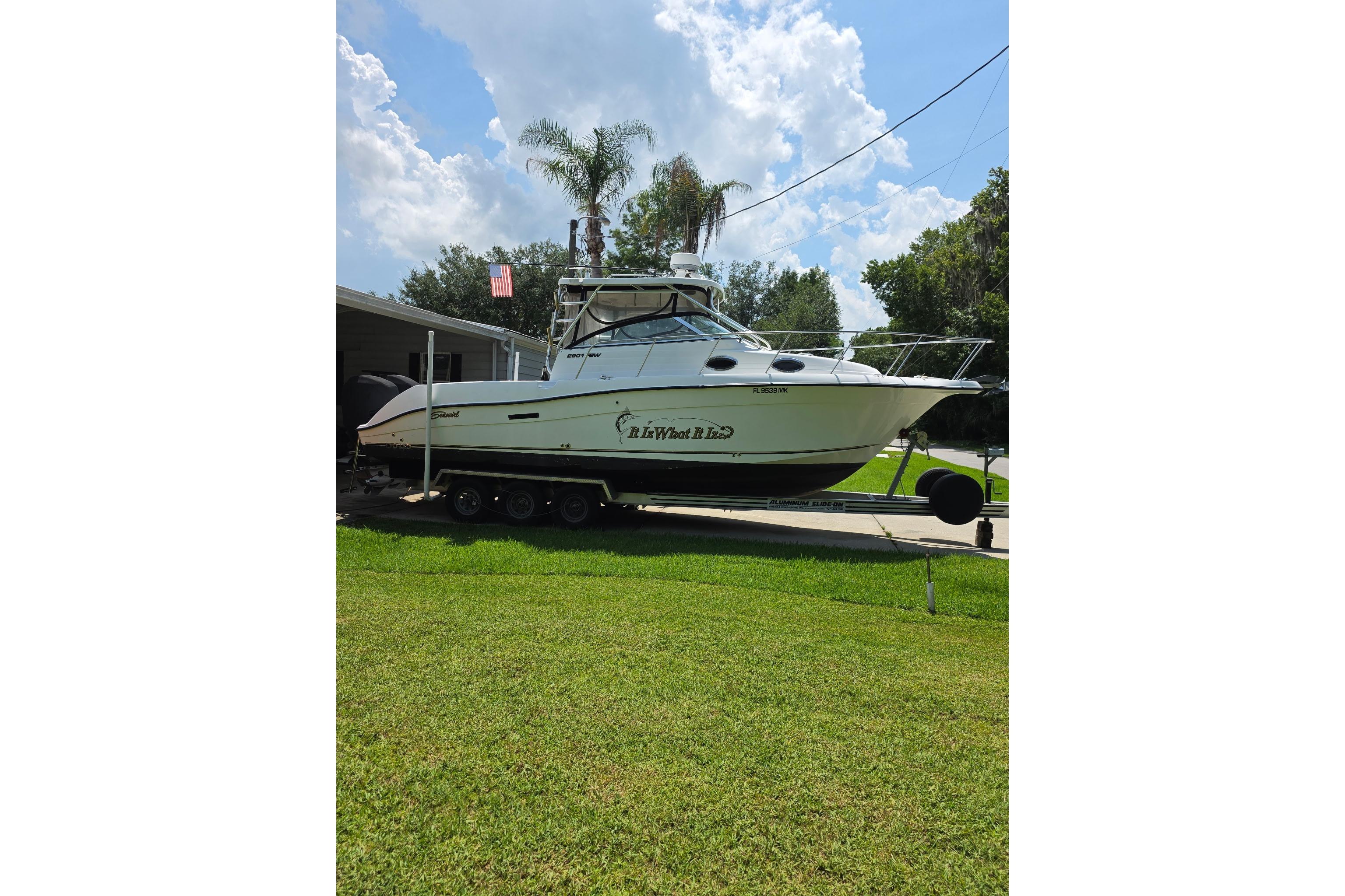 2007 Seaswirl Striper 2901 Walkaround O/B boat on trailer, parked in a grassy yard.