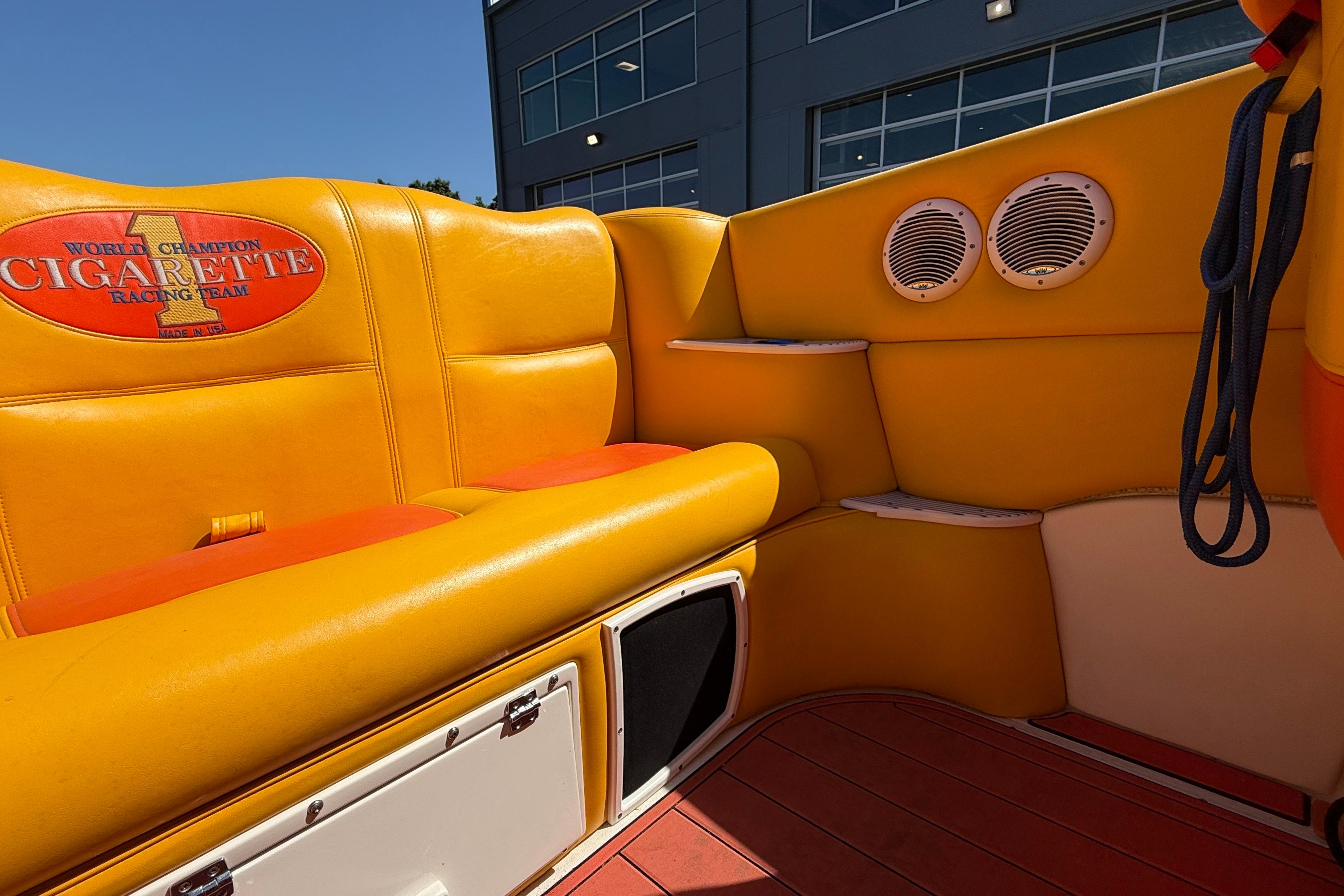 Interior of 2002 Cigarette 35' Cafe Racer with vibrant yellow seating and branded logo.