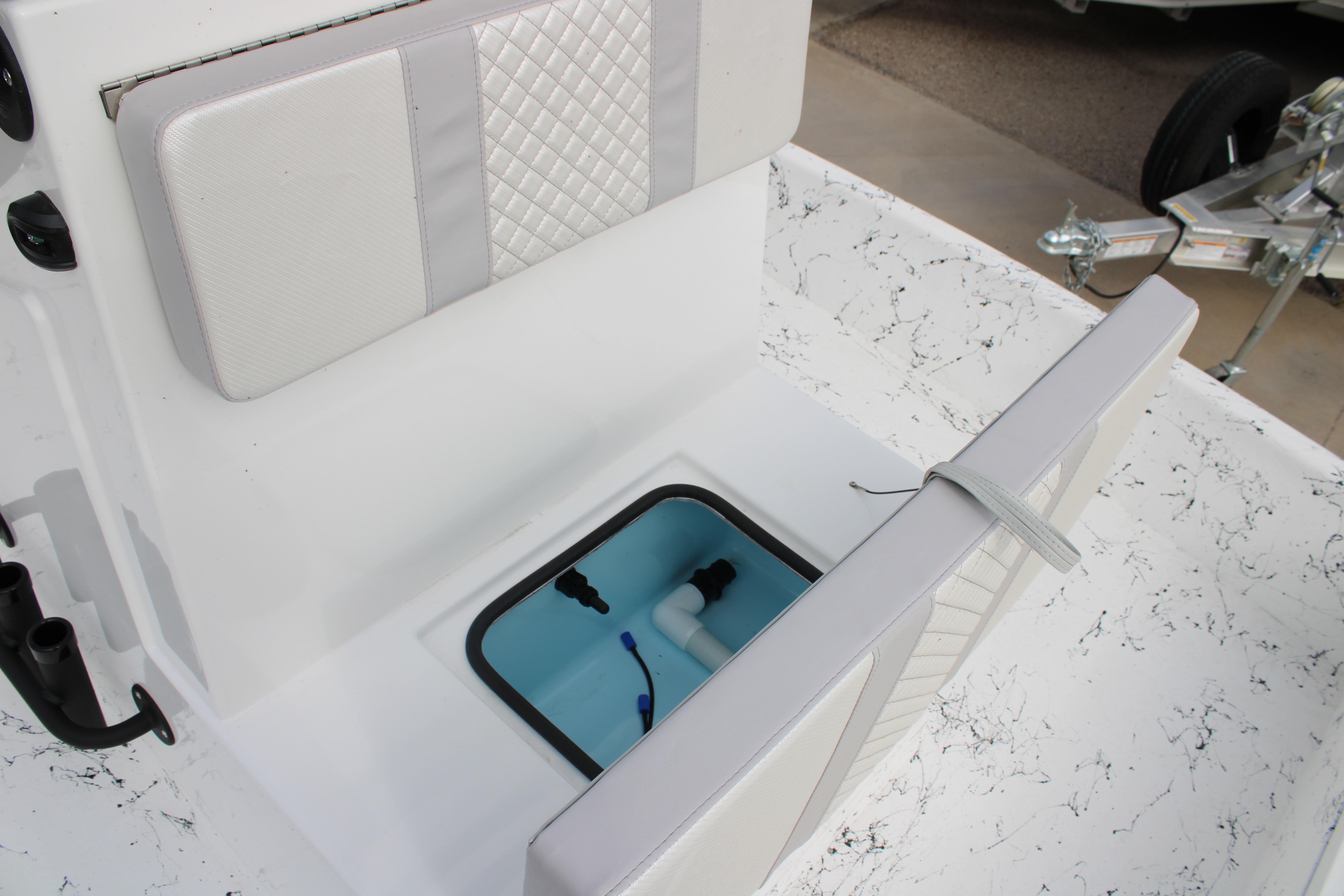 2026 Freedom Boats 19 PATRIOT interior with storage compartment and cushioned seating.