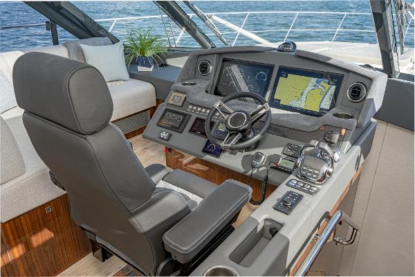 2021 Riviera 5400 Sport Yacht helm with navigation screens and luxurious seating.