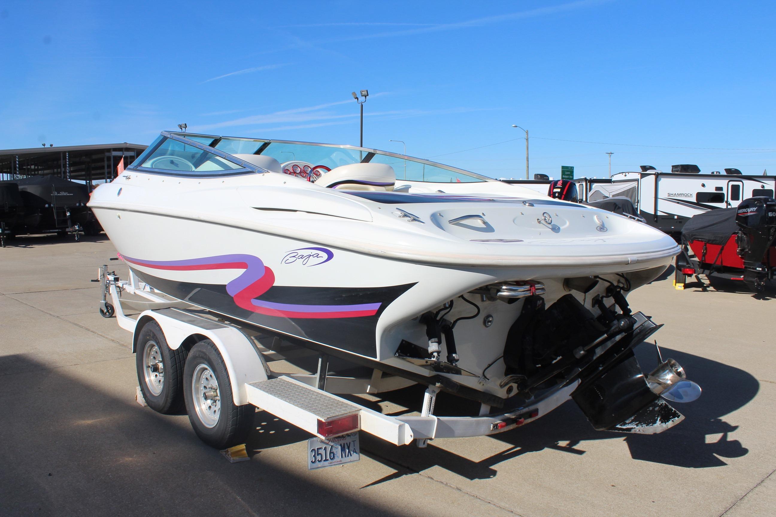 1996 Baja 232 speedboat on trailer, white with red and black accents, parked outdoors.
