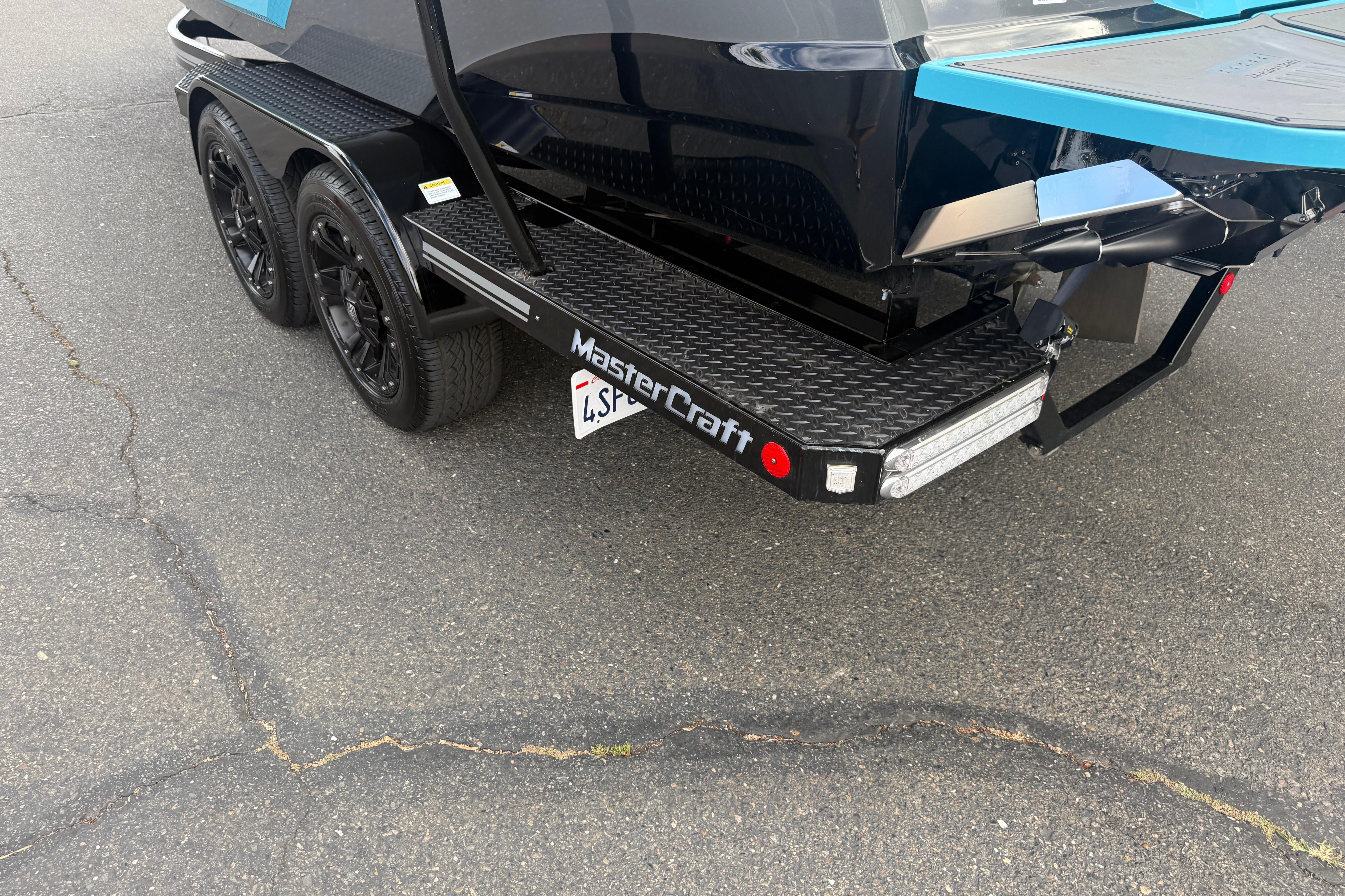 2018 MasterCraft XT21 boat trailer with dual axles and black wheels.
