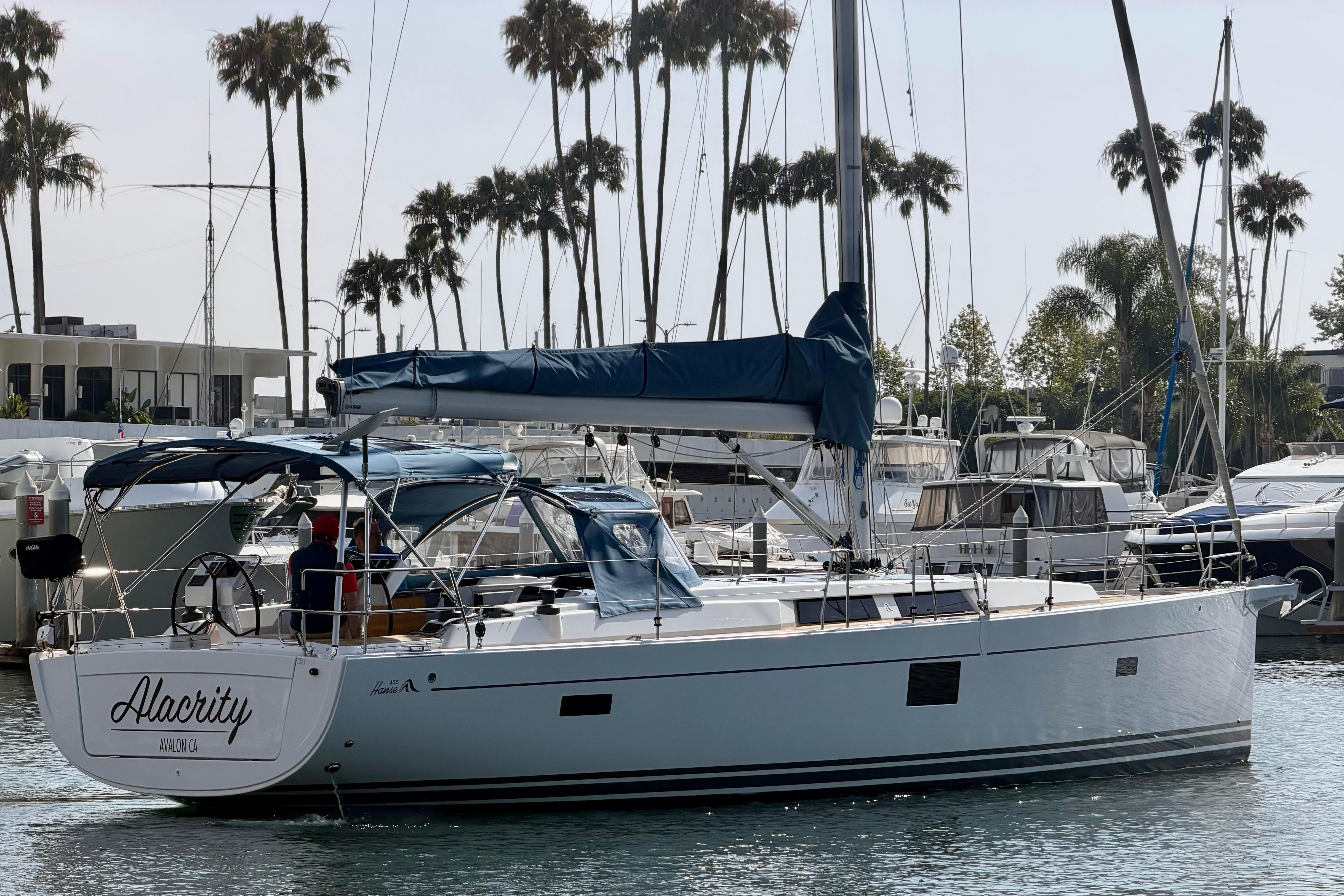 2016 Hanse 455 sailboat docked in marina with palm trees in background.