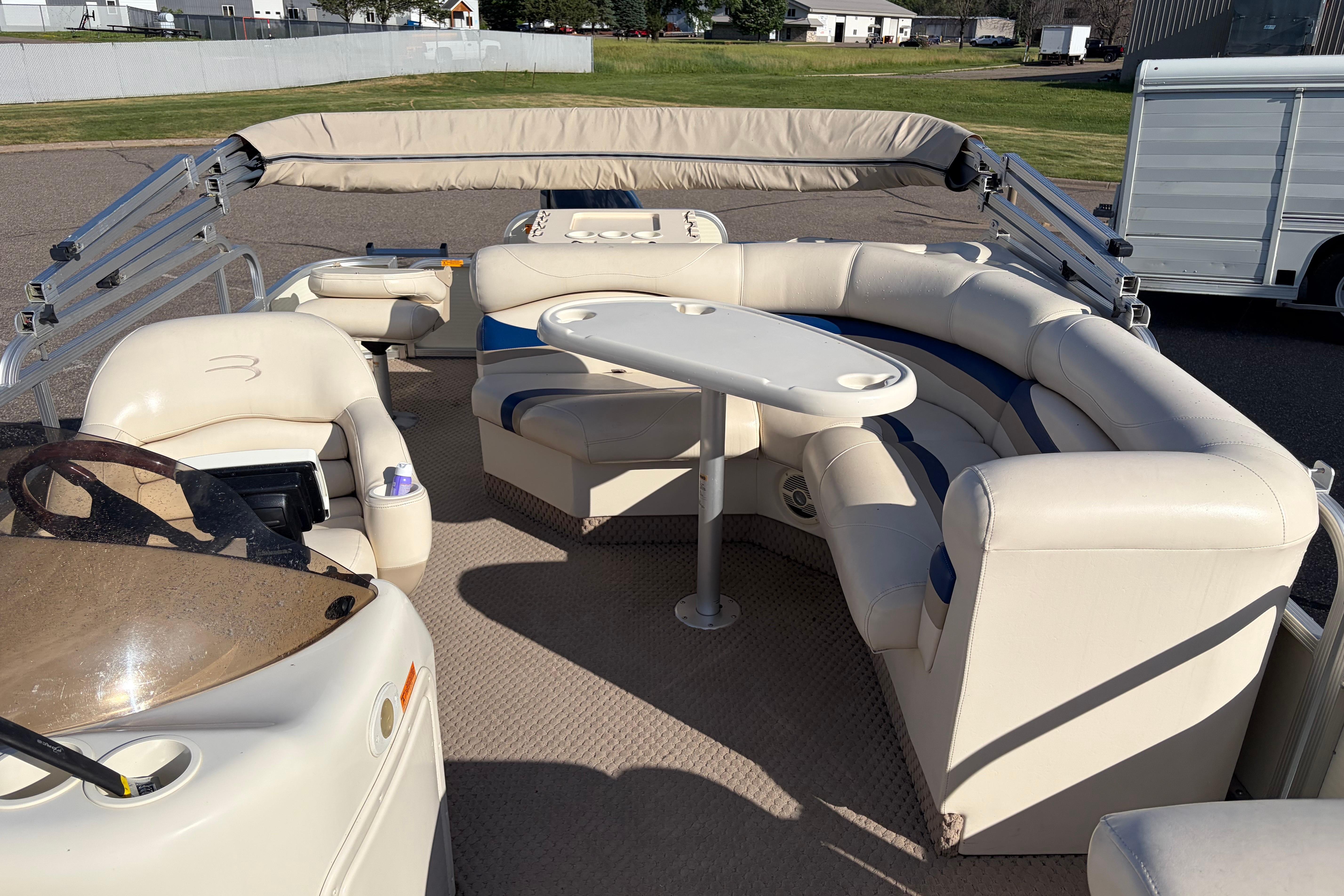 2003 Bennington 2250RSi pontoon boat interior with beige seating and table.
