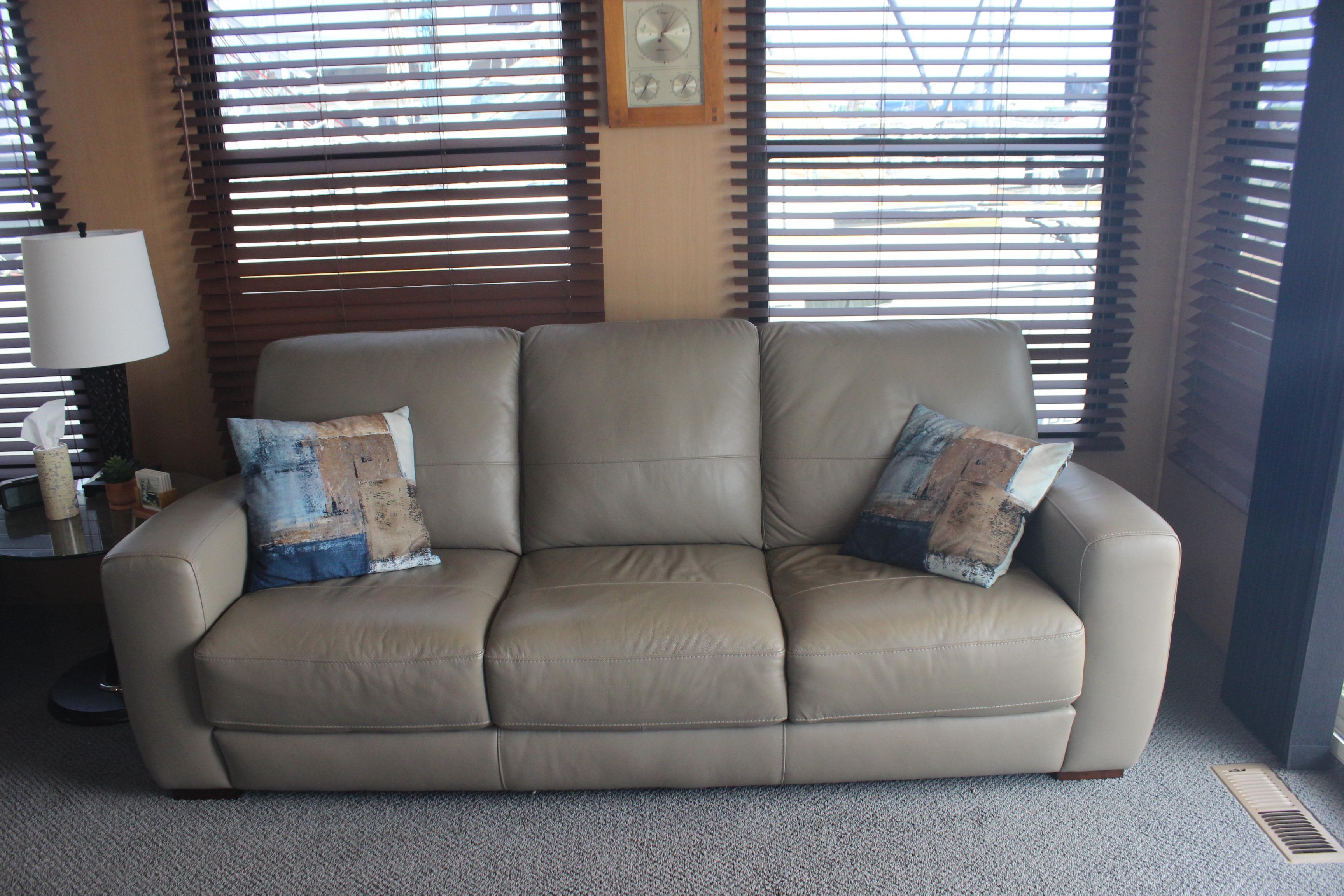 Beige leather sofa with decorative pillows in a cozy room on a Skipperliner 480 Flybridge.